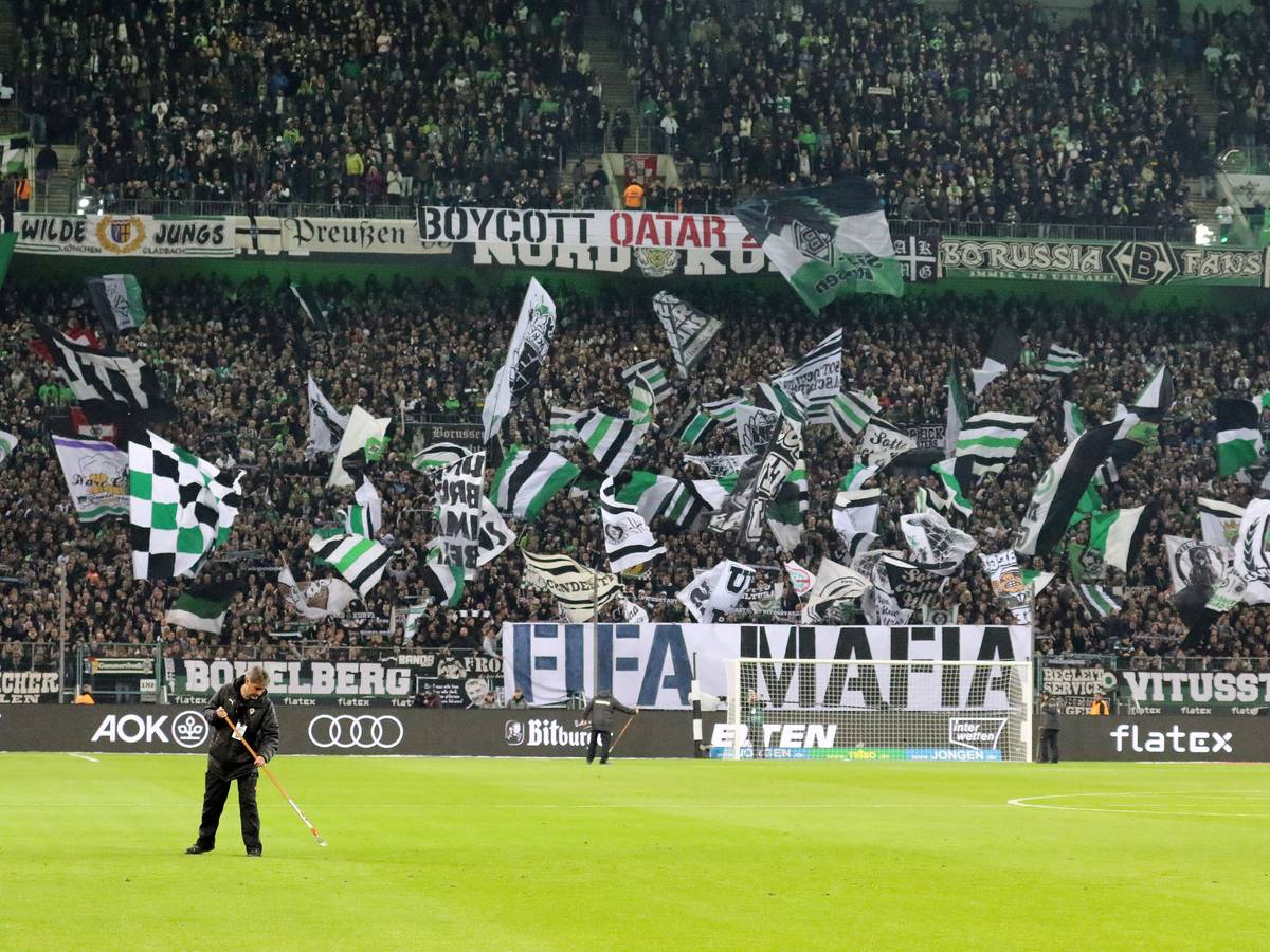 Die Fans in der Nordkurve im Borussia-Park: Dieses Foto zeigt den Anhang von Fußball-Bundesligist Borussia Mönchengladbach vor der Partie gegen Borussia Dortmund (11. November 2022). Im Vordergrund ist noch ein Greenkeeper bei der Arbeit kurz vor Anpfiff zu sehen.
