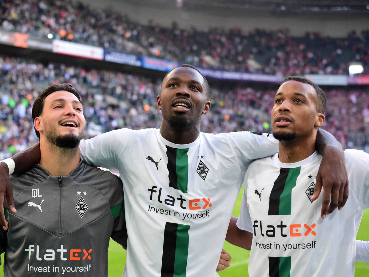 Die Gladbach-Profis Alassane Plea, Marcus Thuram und Ramy Bensebaini (v.r.n.l.). Auf diesem Bild sind Borussia-Stars nach dem Derby-Sieg gegen 1. FC Köln am 9. Oktober 2022 im Borussia-Park zu sehen. Die Spieler umarmen sich und lächeln derweil