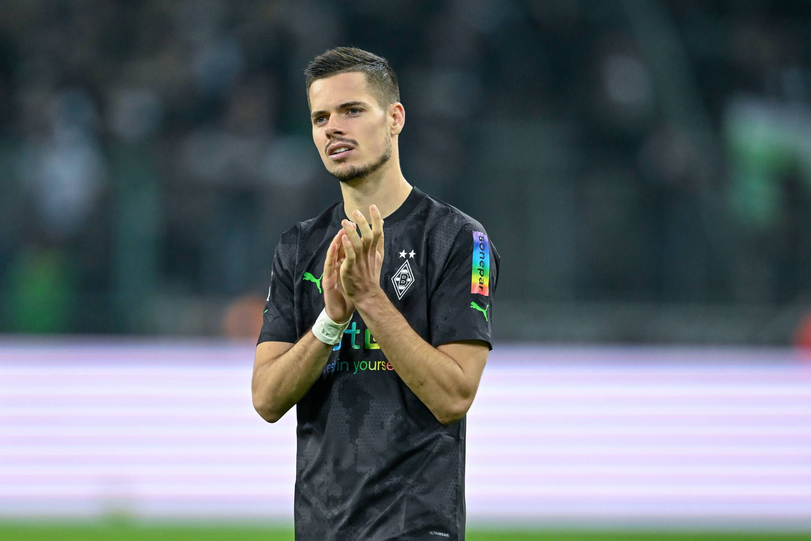 Gladbach-Profi Julian Weigl, auf diesem Foto am 11. November 2022 im Borussia-Park nach der Bundesliga-Partie gegen Borussia Dortmund zu sehen. Der Mittelfeldspieler trägt ein dunkles Trikot und klatscht in die Hände.