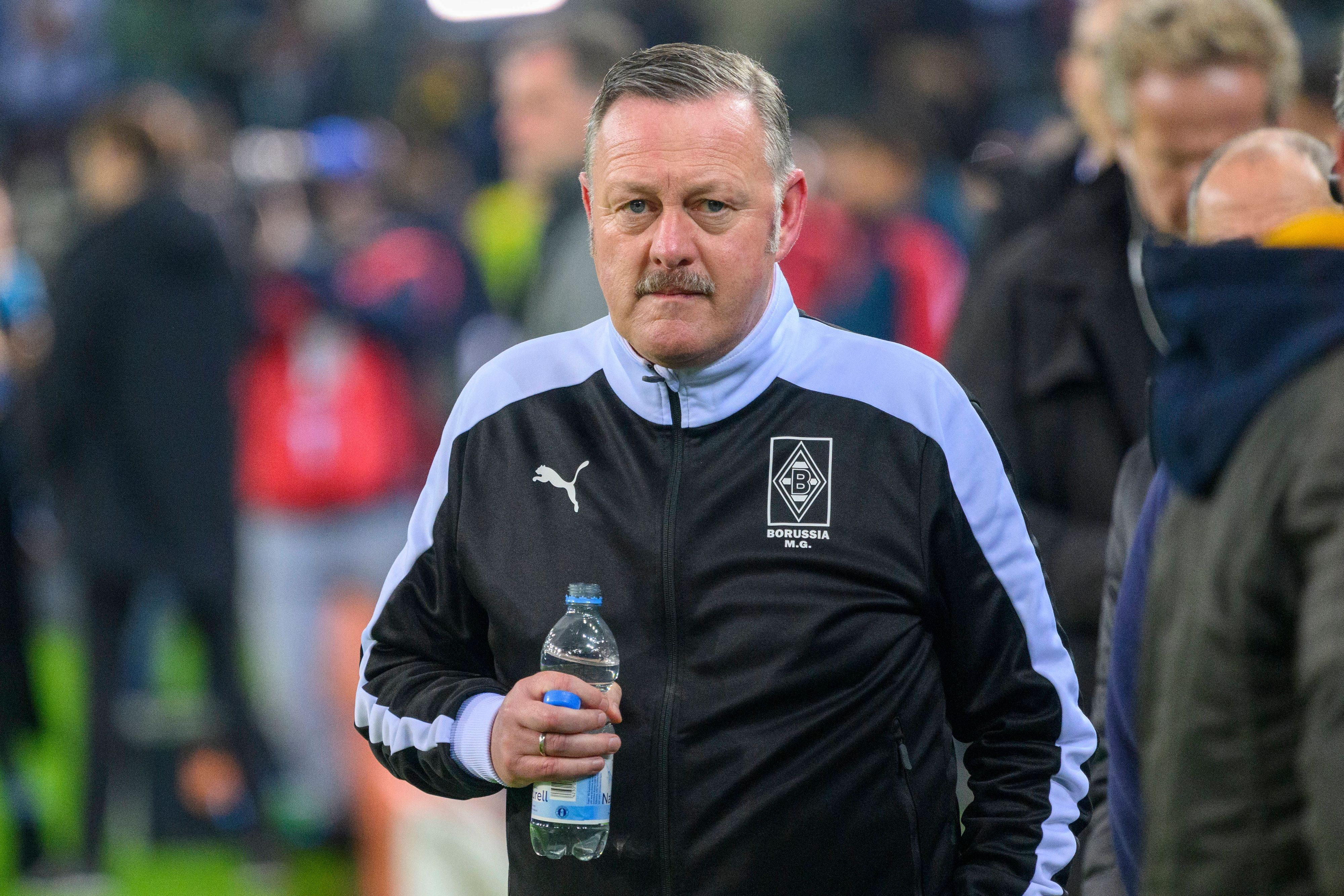 Gladbach-Manager Roland Virkus, auf diesem Foto am 11. November 2022 im Borussia-Park zu sehen. Virkus trägt eine dunkle Trainingsjacke und hält eine Flasche Mineralwasser in seiner rechten Hand.