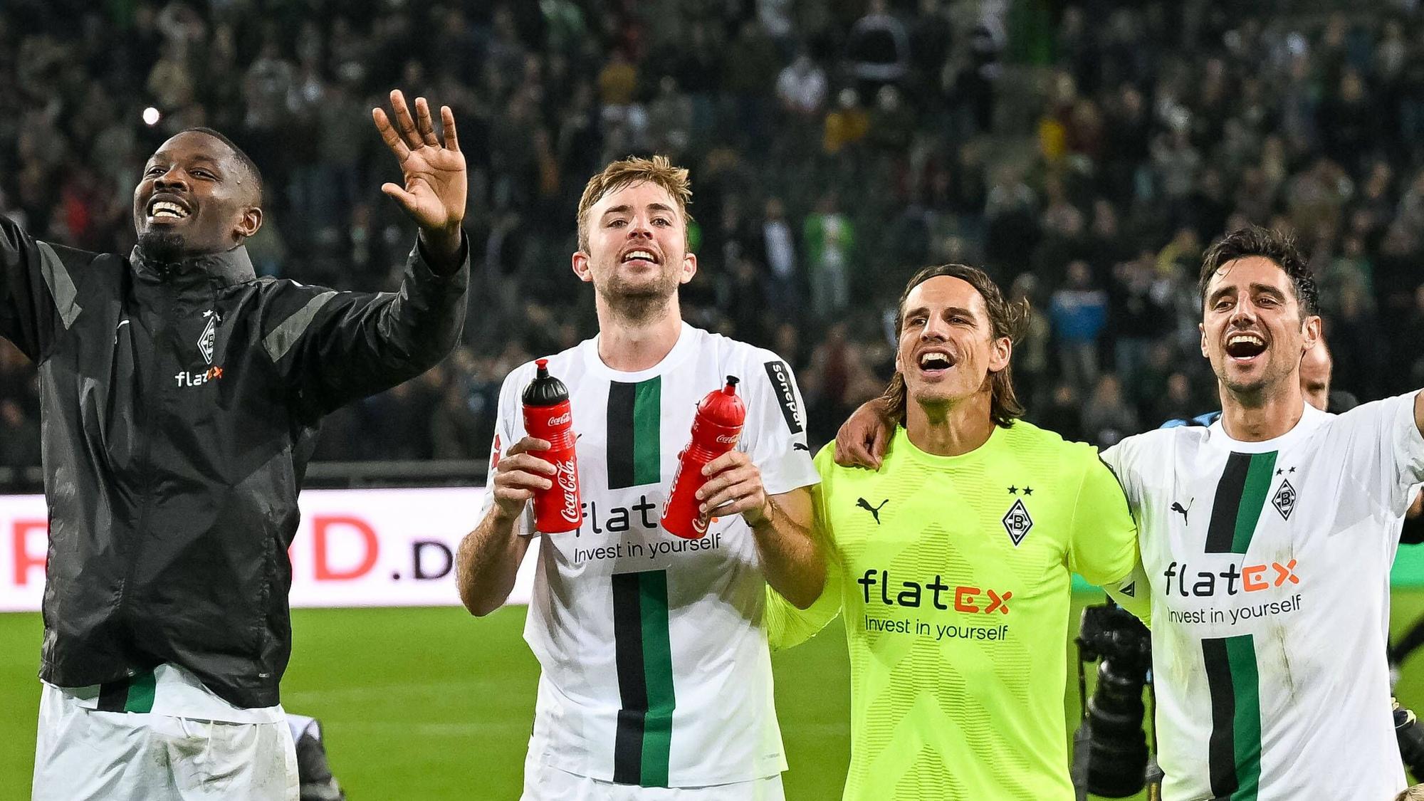 Marcus Thuram, Christoph Kramer, Yann Sommer und Lars Stindl (v. l. n. r.) jubeln am 17. September 2022 nach dem Heimsieg von Borussia Mönchengladbach gegen RB Leipzig gemeinsam vor der Nordkurve im Borussia-Park.