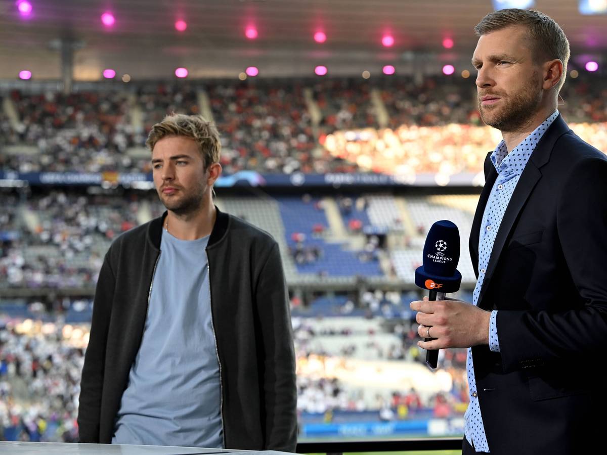 Gladbach-Profi Christoph Kramer (l.) und Per Mertesacker am 28. Mai 2022 beim Champions-League-Finale in Paris. Mertesacker hält ein Mikrofon in der rechten Hand.