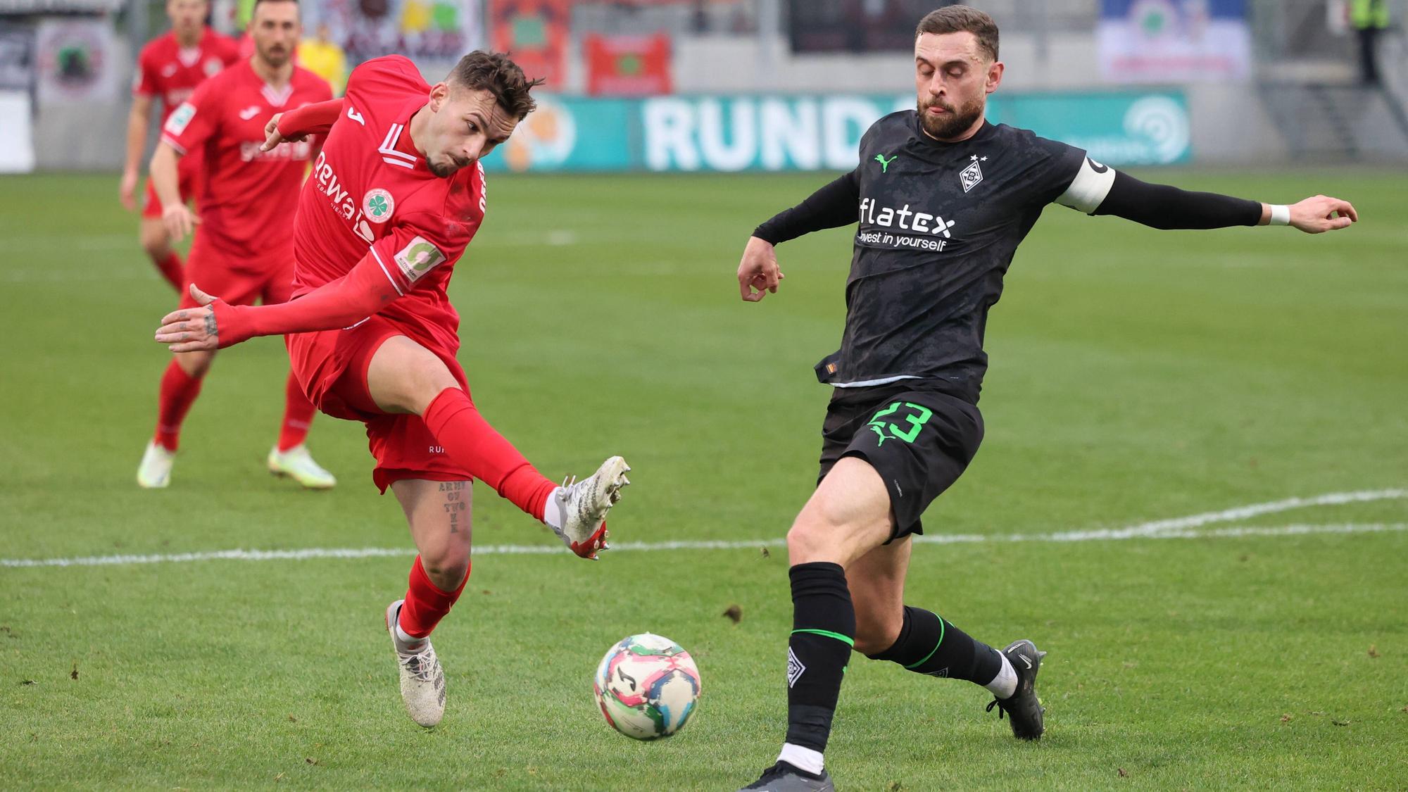 Ein Spieler von Rot-Weiß Oberhausen kommt zum Abschluss, Michel Lieder von Borussia Mönchengladbach blockt den Schuss.