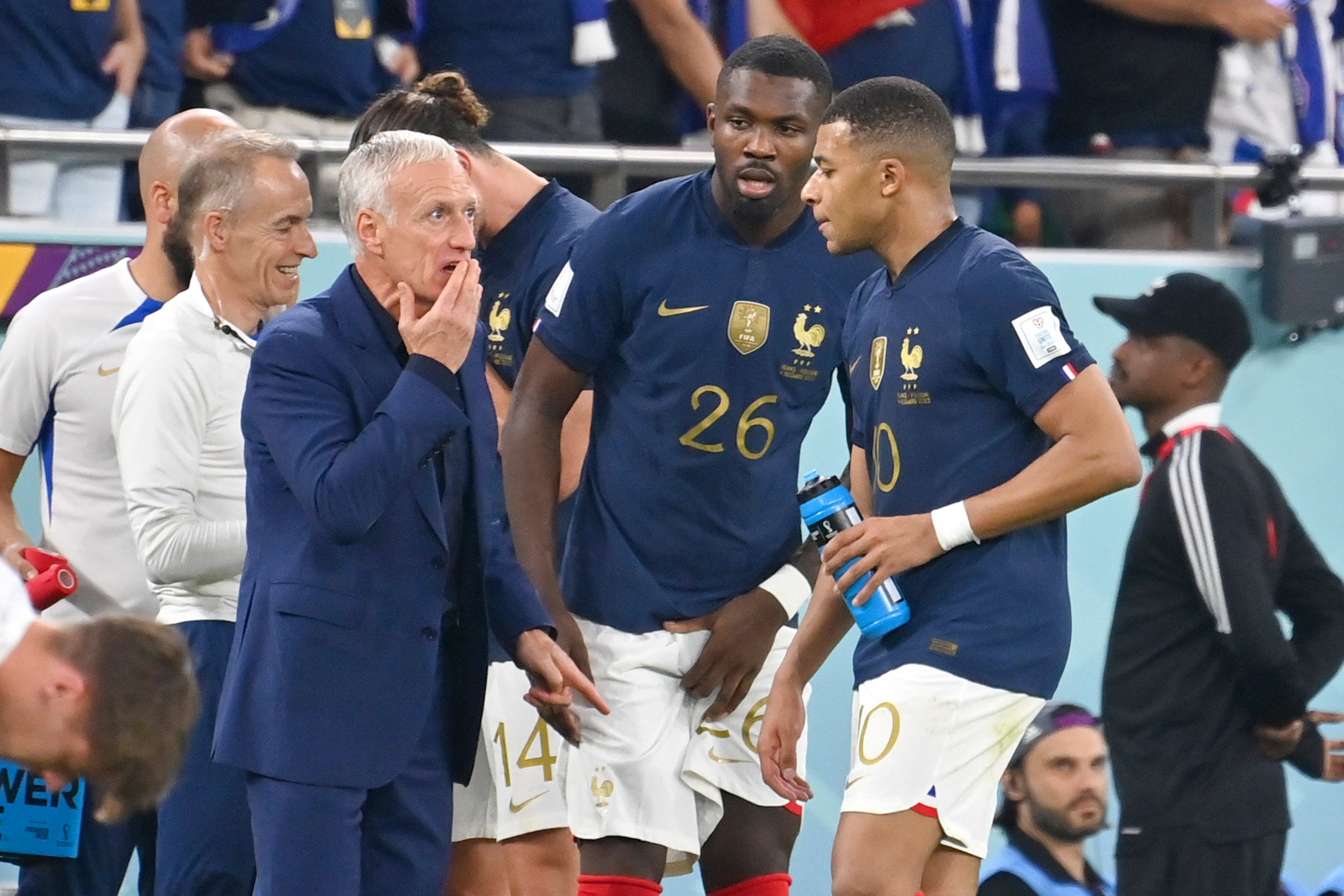 Marcus Thuram (M.) ist der letzte Gladbach-Star bei der Fußball-Weltmeisterschaft in Katar. Auf diesem Foto ist der Stürmer gemeinsam mit Kylian Mbappe (r.) und Trainer Didier Deschamps (l.) am 4. Dezember 2022 zu sehen. Deschamps spricht an der Seitenlinie mit den beiden Spielern.