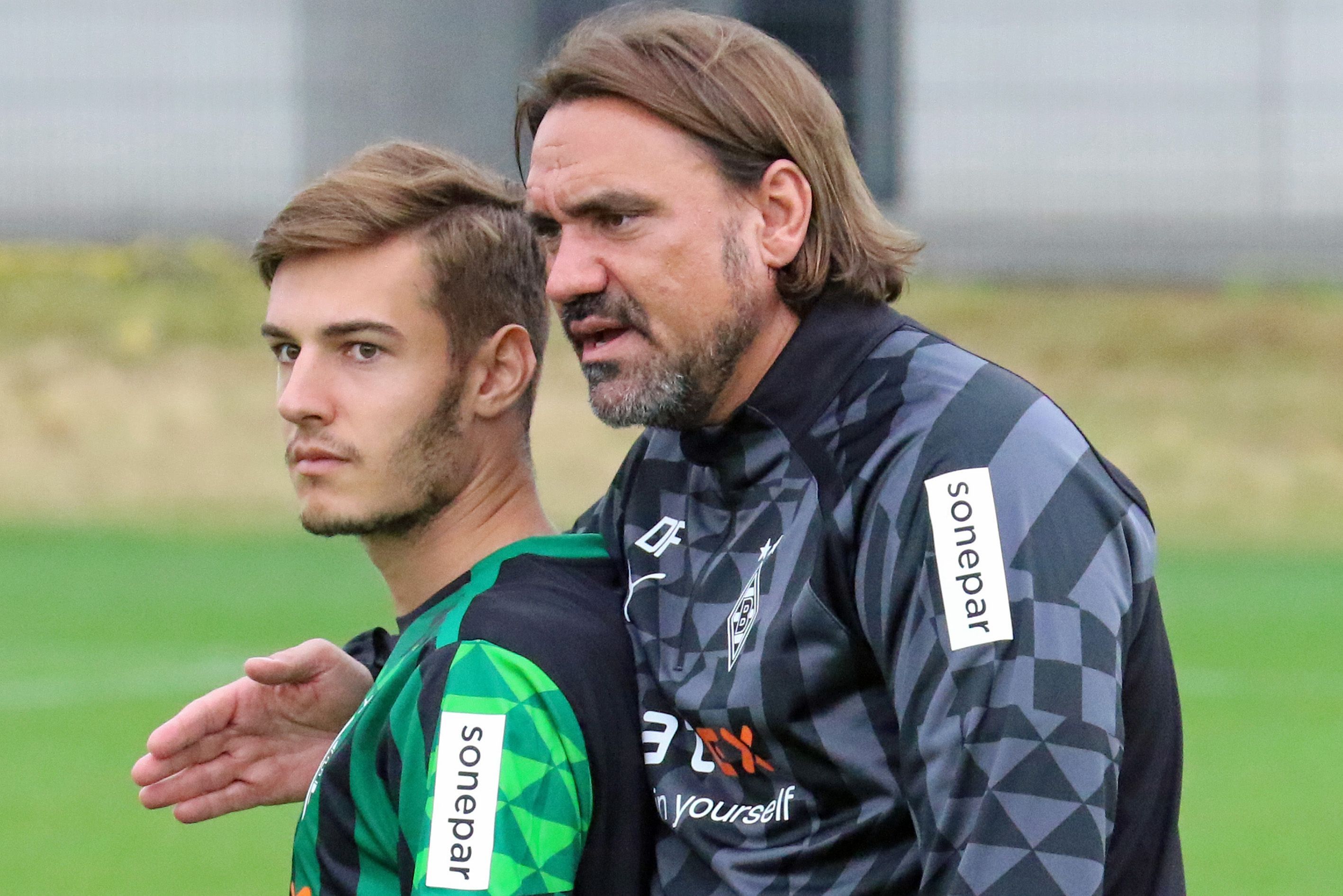 DFB-Nationalspieler und Gladbach-Profi Florian Neuhaus (l.) mit seinem Trainer Daniel Farke (r.) im Borussia-Park. Hier zu sehen am 27. Juni 2022. Farke umarmt Neuhaus und spricht mit ihm.