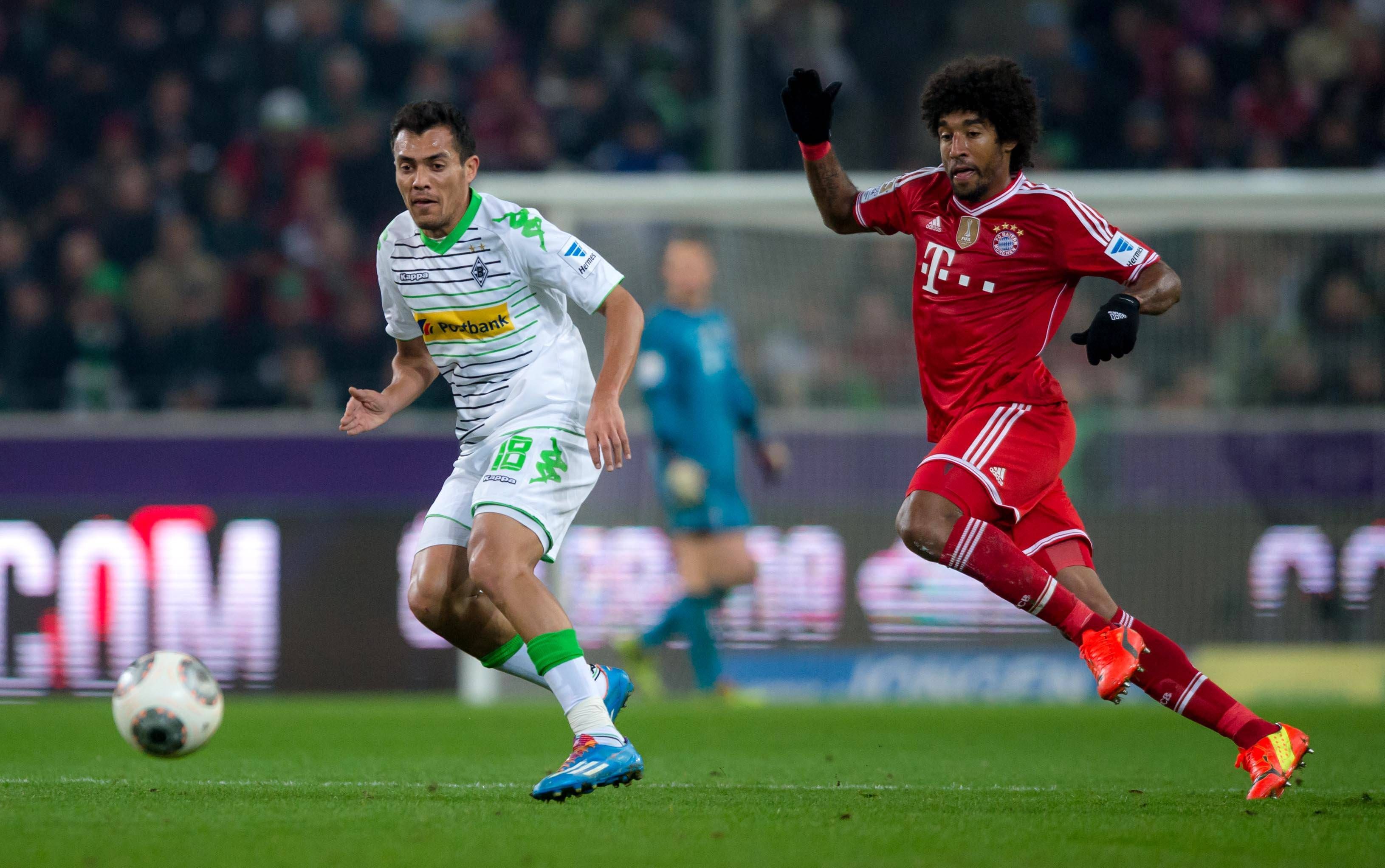 Ex-Gladbach-Star Juan Arango (l.) im Zweikampf mit Dante (r., Bayern München) am 24. Januar 2014 im Borussia-Park. Beide Spieler haben den Ball im Blick.
