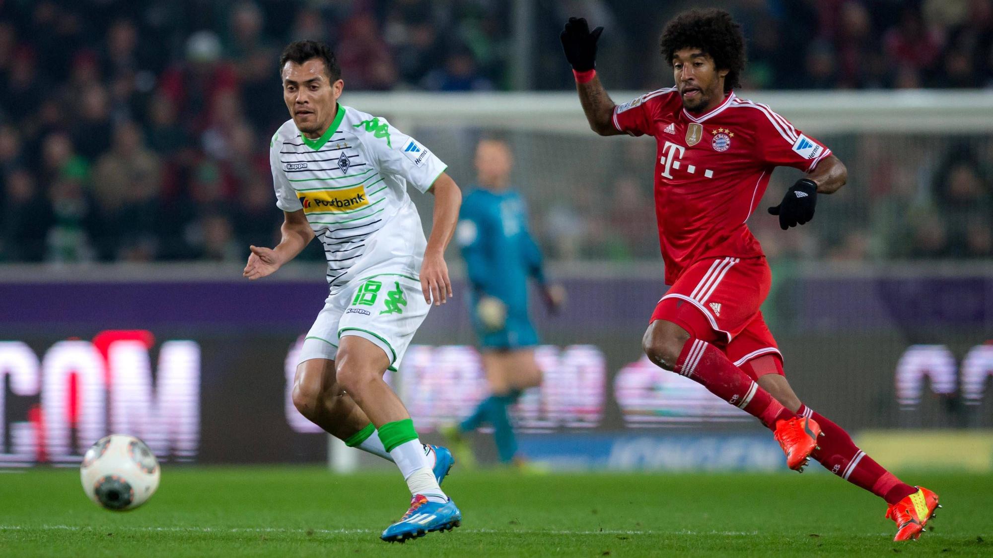 Ex-Gladbach-Star Juan Arango (l.) im Zweikampf mit Dante (r., Bayern München) am 24. Januar 2014 im Borussia-Park. Beide Spieler haben den Ball im Blick.