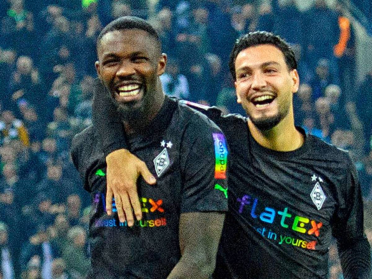 Pure Freude: Die Gladbach-Profis Marcus Thuram (l.) und Ramy Bensebaini (r.) bejubeln den Bundesliga-Sieg gegen Borussia Dortmund am 11. November 2022 im Borussia-Park. Bensebaini umarmt Thuram, beide Borussia-Profis strahlen vor Glück.