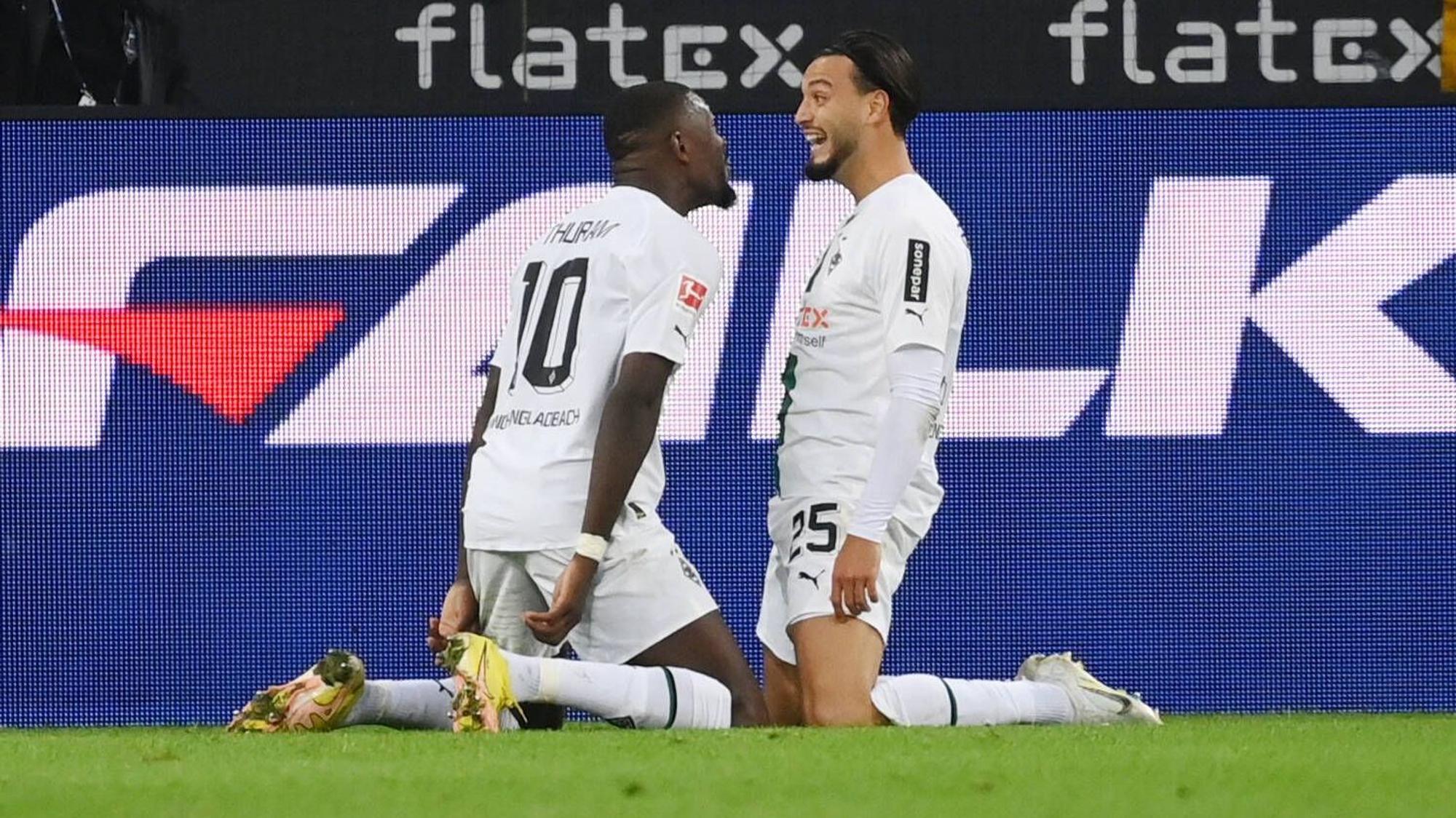 Da jubeln sie noch gemeinsam im Gladbach-Trikot: Linksverteidiger Ramy Bensebaini (r.) und Stürmer Marcus Thuram, hier am 17. September 2022 im Borussia-Park zu sehen. Sie knien auf dem Rasen.