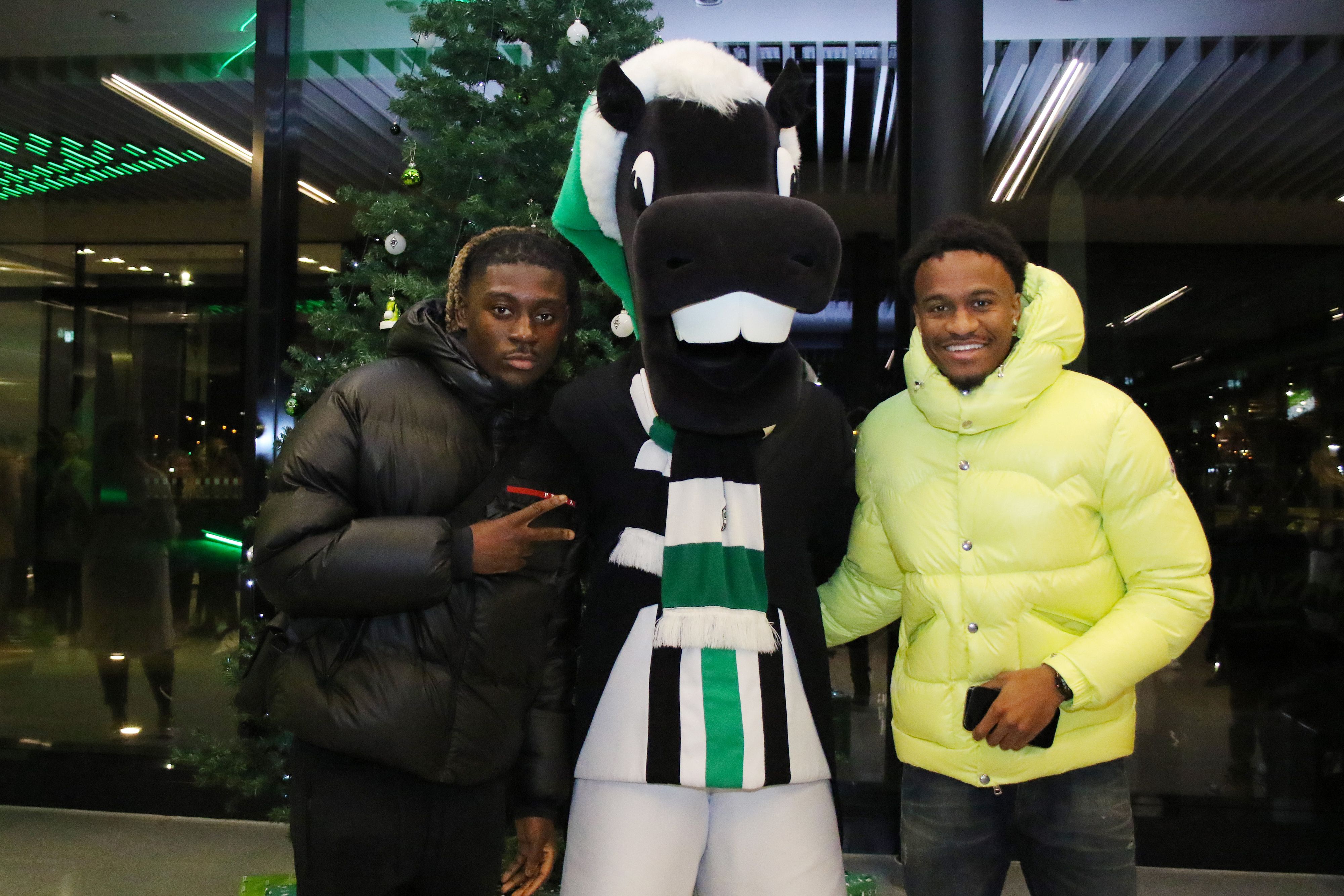 Manu Koné (l.) und Nathan Ngoumou (r.) posieren gemeinsam mit Maskottchen Jünter bei der Weihnachtsfeier von Borussia Mönchengladbach im Borussia-Park am 11. Dezember 2022.