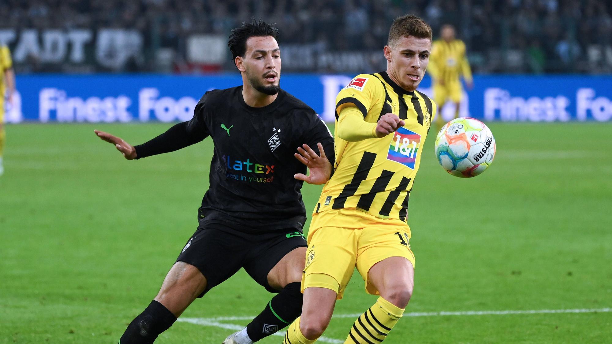 Ramy Bensebaini von Borussia Mönchengladbach versucht, Thorgan Hazard von Borussia Dortmund bei einem Bundesliga-Spiel am 11. November 2022 im Zweikampf den Ball abzunehmen.