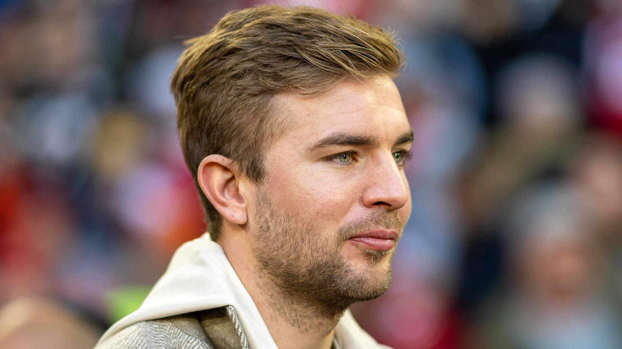 Christoph Kramer steht in Straßenkleidung im Stadion in München.