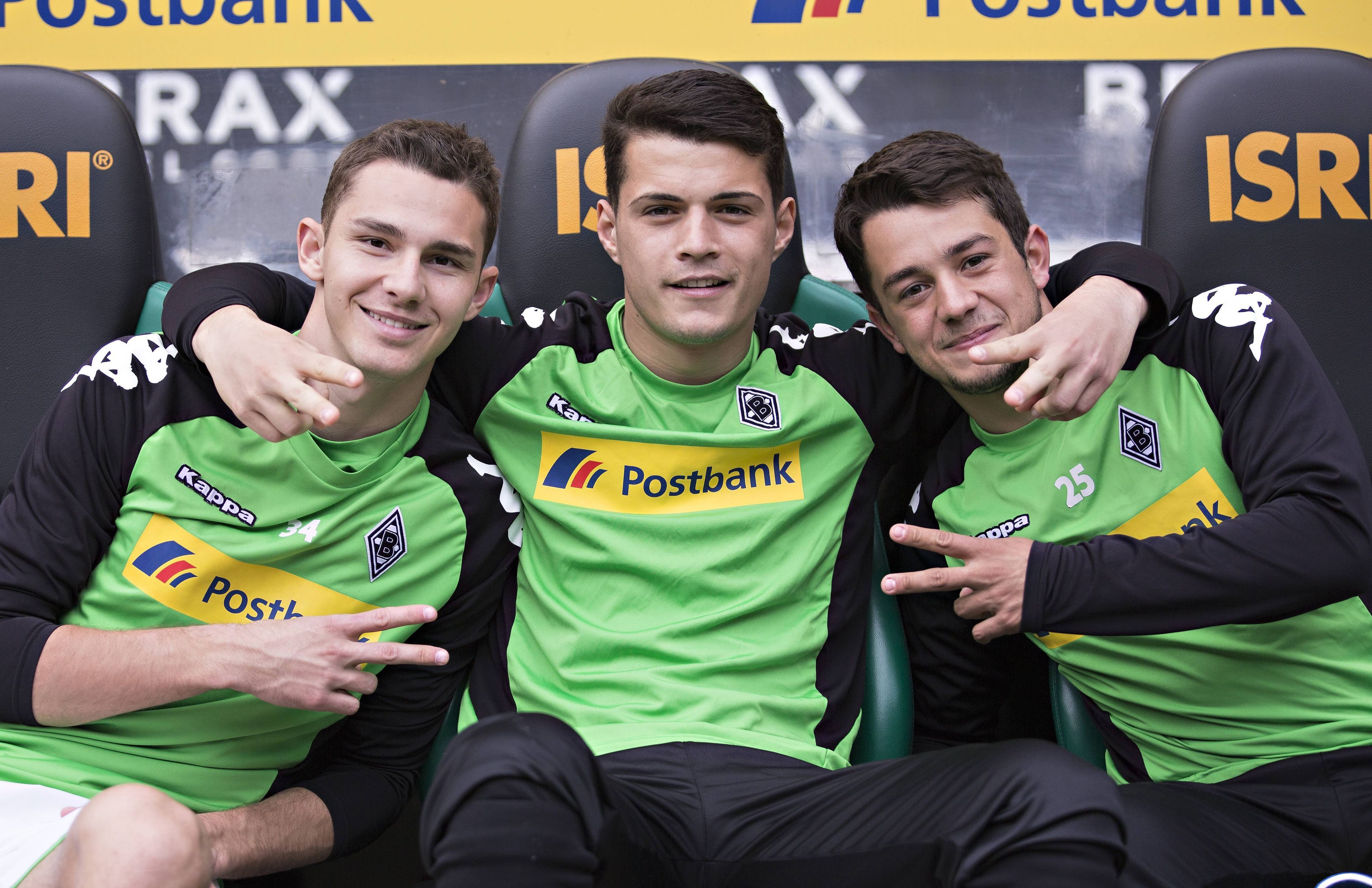 Amin Younes posiert mit Branimir Hrgota und Granit Xhaka für ein Foto auf der Bank von Borussia Mönchengladbach.