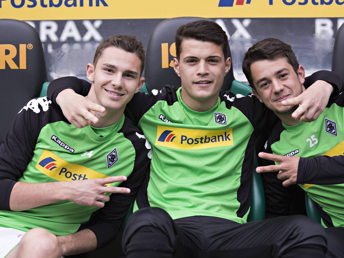 Amin Younes posiert mit Branimir Hrgota und Granit Xhaka für ein Foto auf der Bank von Borussia Mönchengladbach.