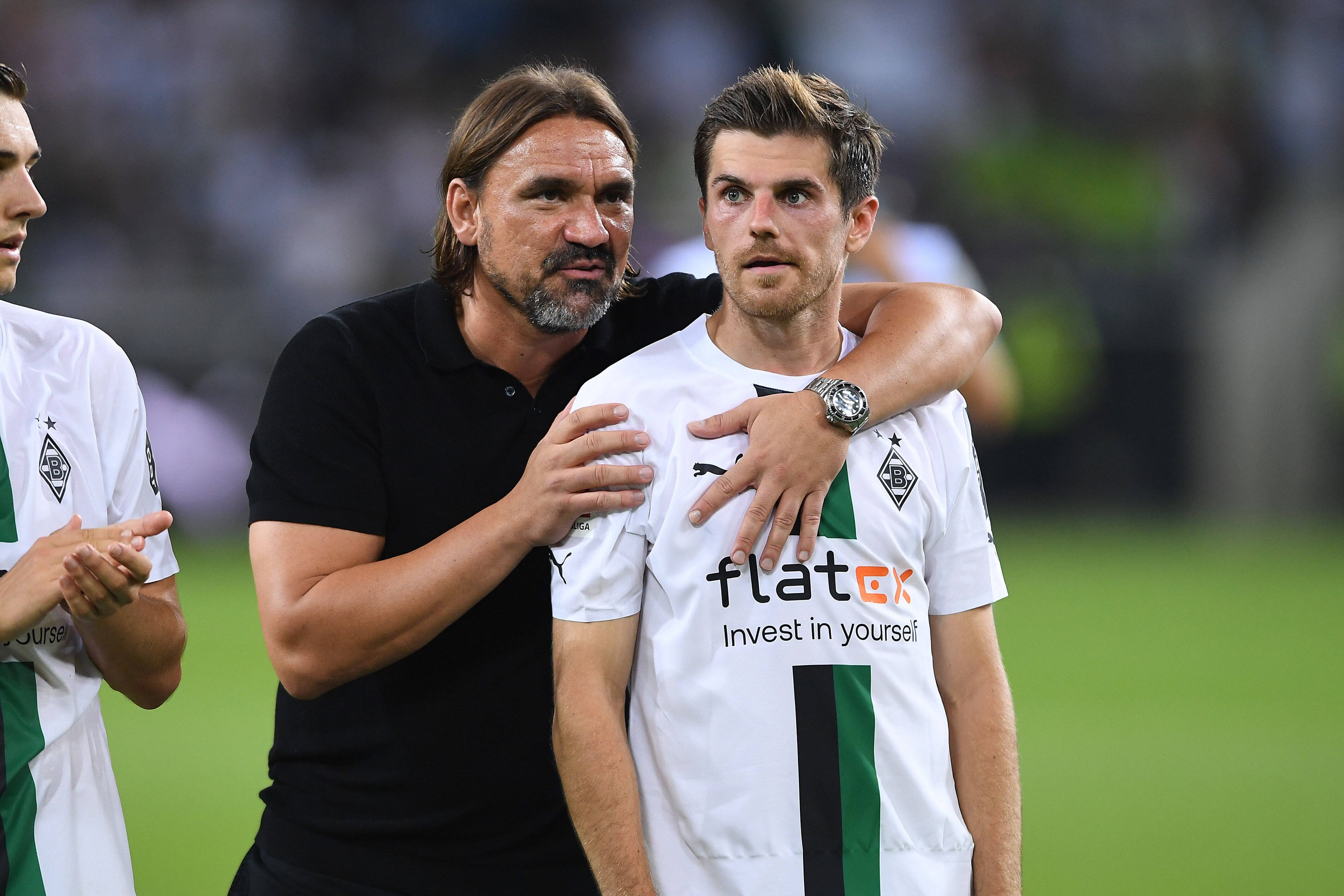 Daniel Farke umarmt Jonas Hofmann nach einem Bundesliga-Spiel von hinten.