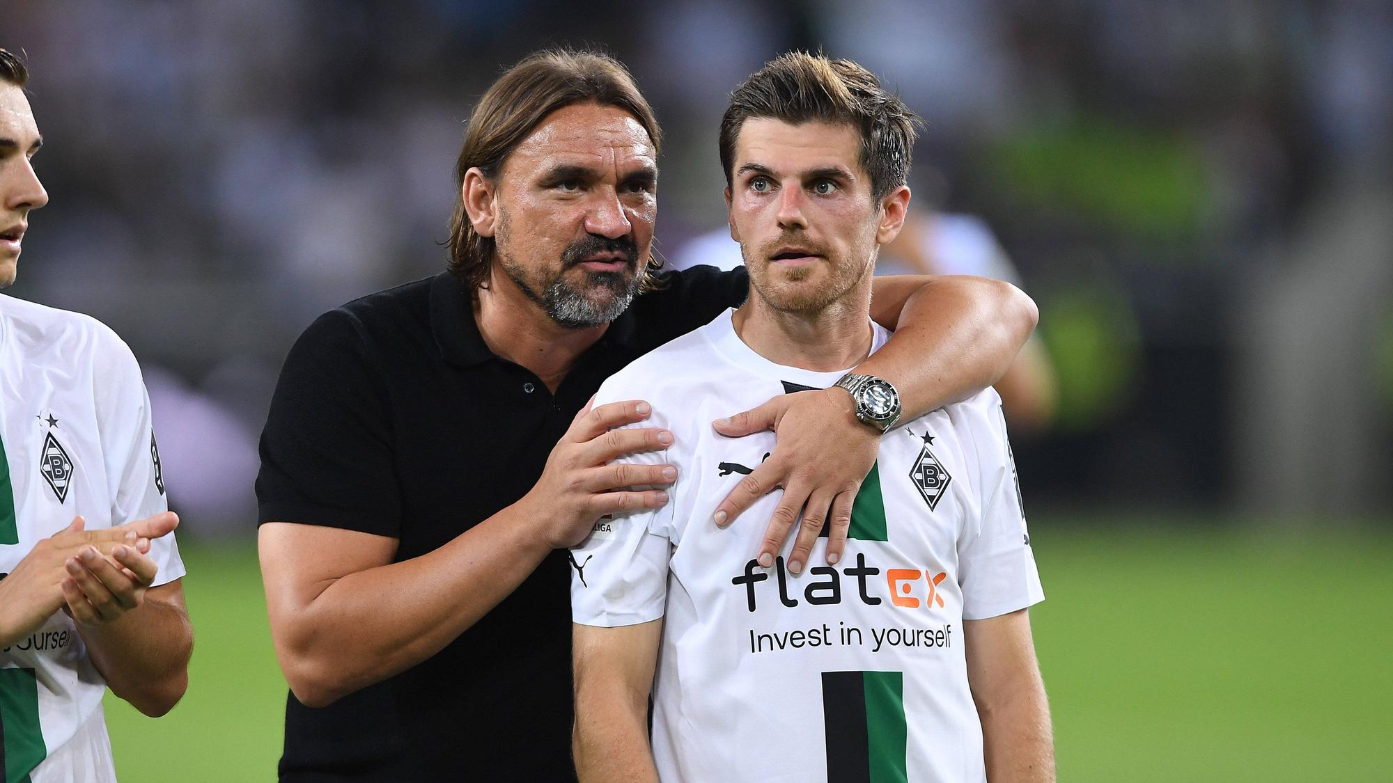 Daniel Farke umarmt Jonas Hofmann nach einem Bundesliga-Spiel von hinten.