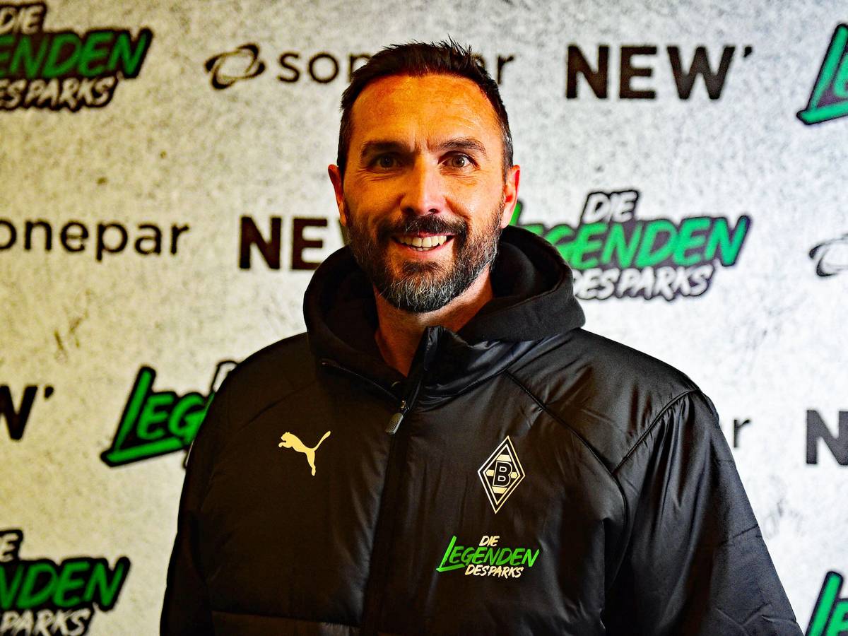 Ex-Gladbach-Kapitän Martin Stranzl, auf diesem Foto am 17. Dezember 2022, vor dem Legendenspiel im Borussia-Park, zu sehen. Stranzl steht vor einer Werbe-Tafel, er lächelt in die Kamera.