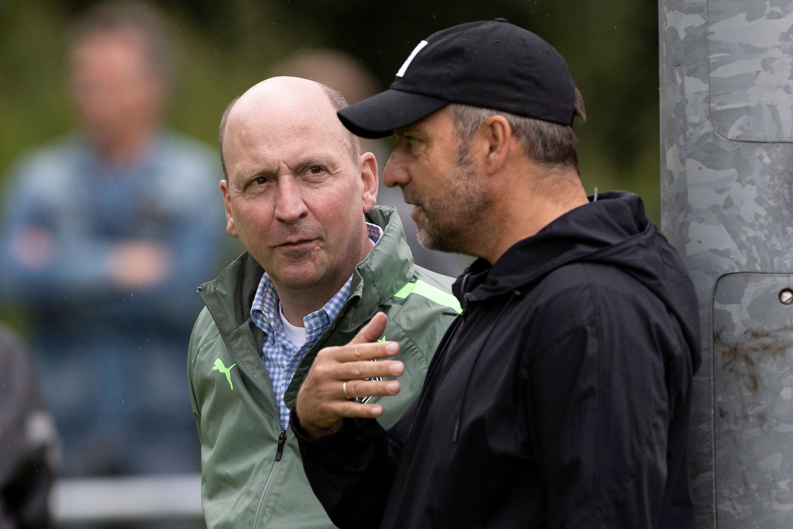 Gladbach-Boss Stephan Schippers (l.) im Gespräch mit DFB-Bundestrainer Hansi Flick, hier zu sehen am 7. Juli 2022 während des Borussia-Trainingslagers in Rottach-Egern am Tegernsee. Flick spricht und gestikuliert, Schippers hört derweil zu.