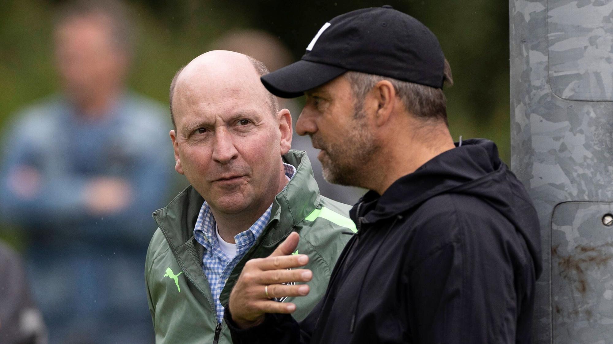 Gladbach-Boss Stephan Schippers (l.) im Gespräch mit DFB-Bundestrainer Hansi Flick, hier zu sehen am 7. Juli 2022 während des Borussia-Trainingslagers in Rottach-Egern am Tegernsee. Flick spricht und gestikuliert, Schippers hört derweil zu.