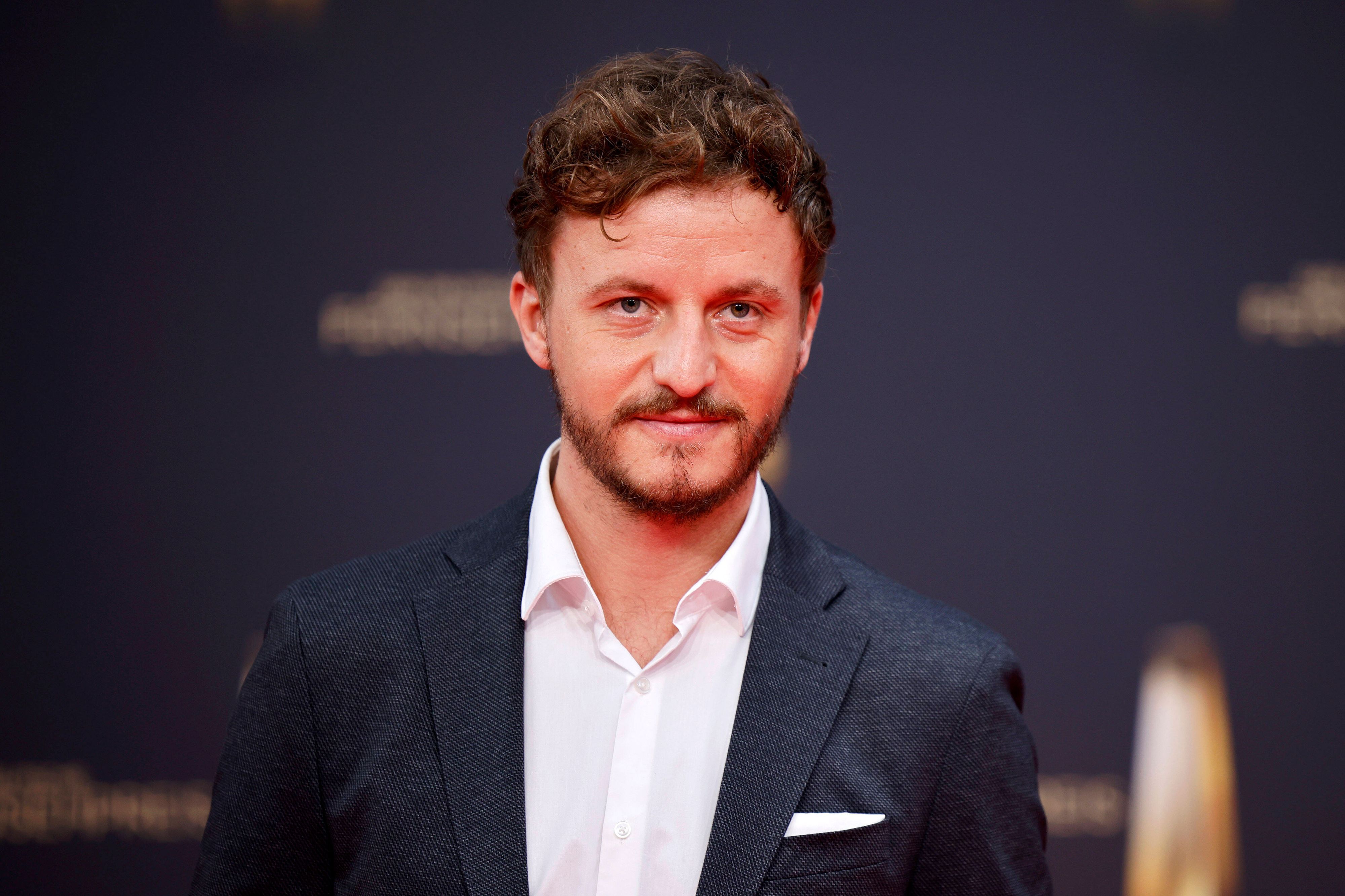 Tommi Schmitt, hier bei der Verleihung des Deutschen Fernsehpreises am 14. September 2022, lächelnd mit Anzug und weißem Hemd.