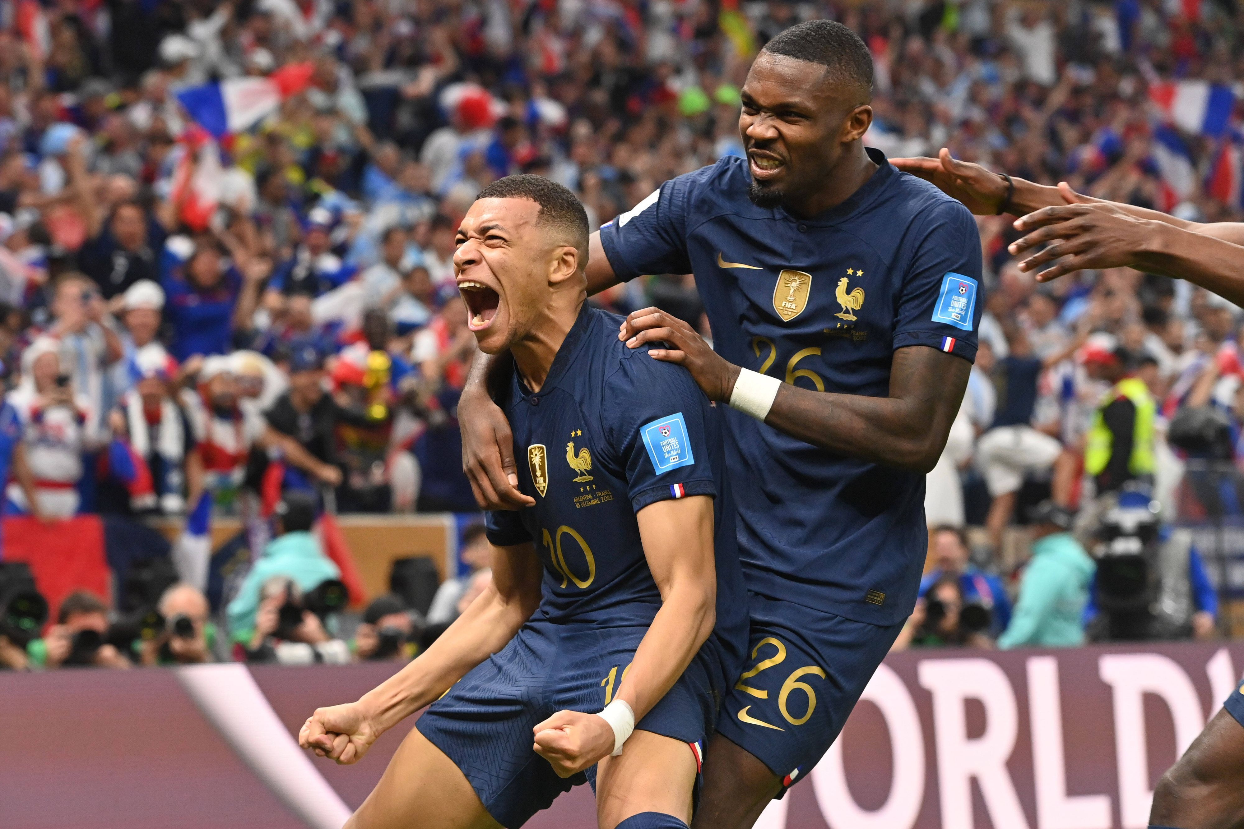 Kylian Mbappe jubelt nach seinem Treffer zum 2:2 für Frankreich im WM-Finale gegen Argentinien am 18. Dezember 2022 und schreit seine Freude heraus. Von hinten umarmt ihn Teamkollege Marcus Thuram.