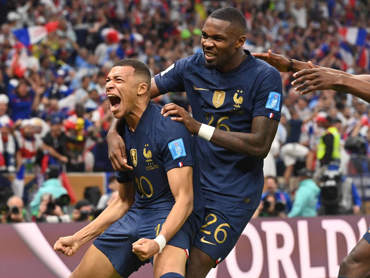 Kylian Mbappe jubelt nach seinem Treffer zum 2:2 für Frankreich im WM-Finale gegen Argentinien am 18. Dezember 2022 und schreit seine Freude heraus. Von hinten umarmt ihn Teamkollege Marcus Thuram.
