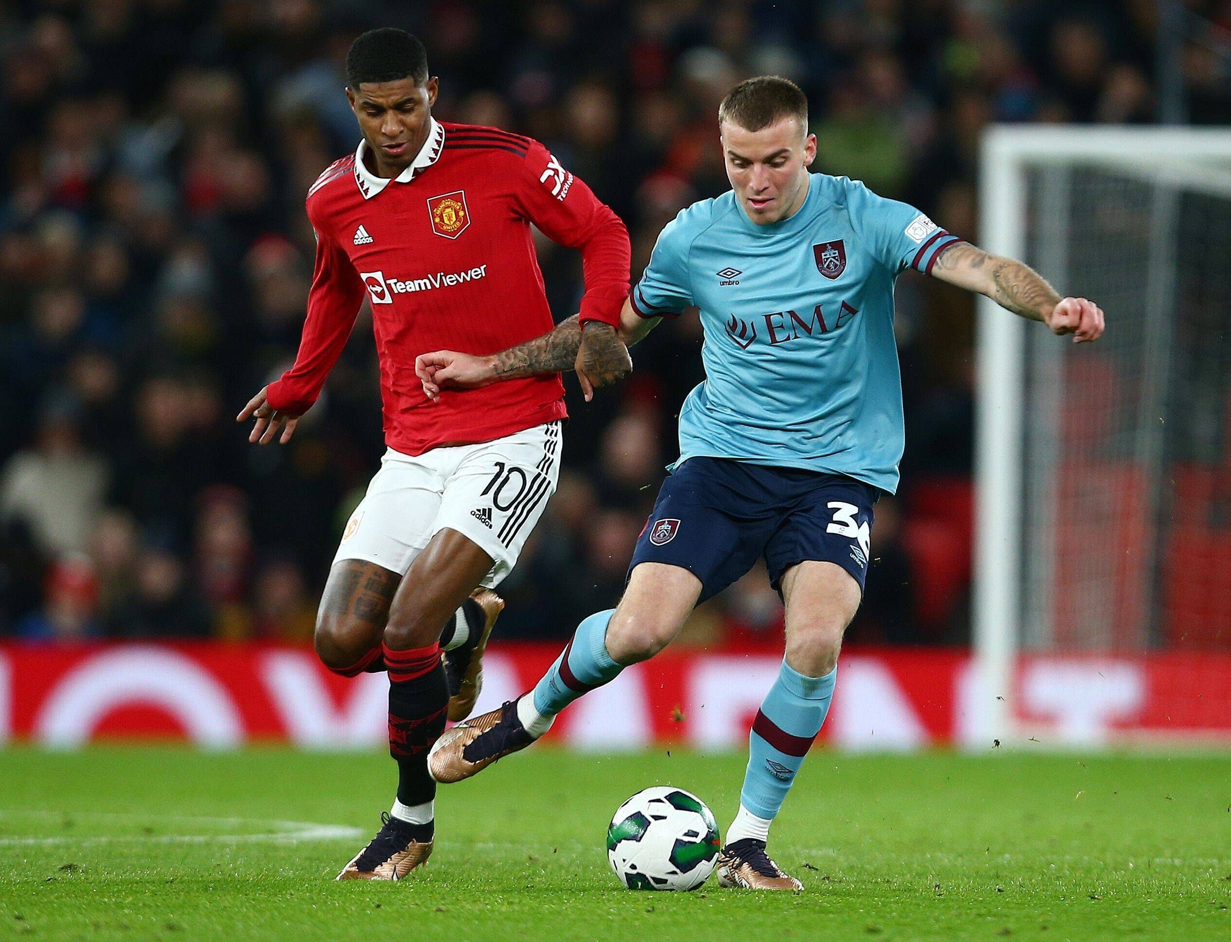 Jordan Beyer bestreitet im blauen Auswärtstrikot des FC Burnley einen Zweikampf mit Marcus Rashford, Spieler von Manchester United.