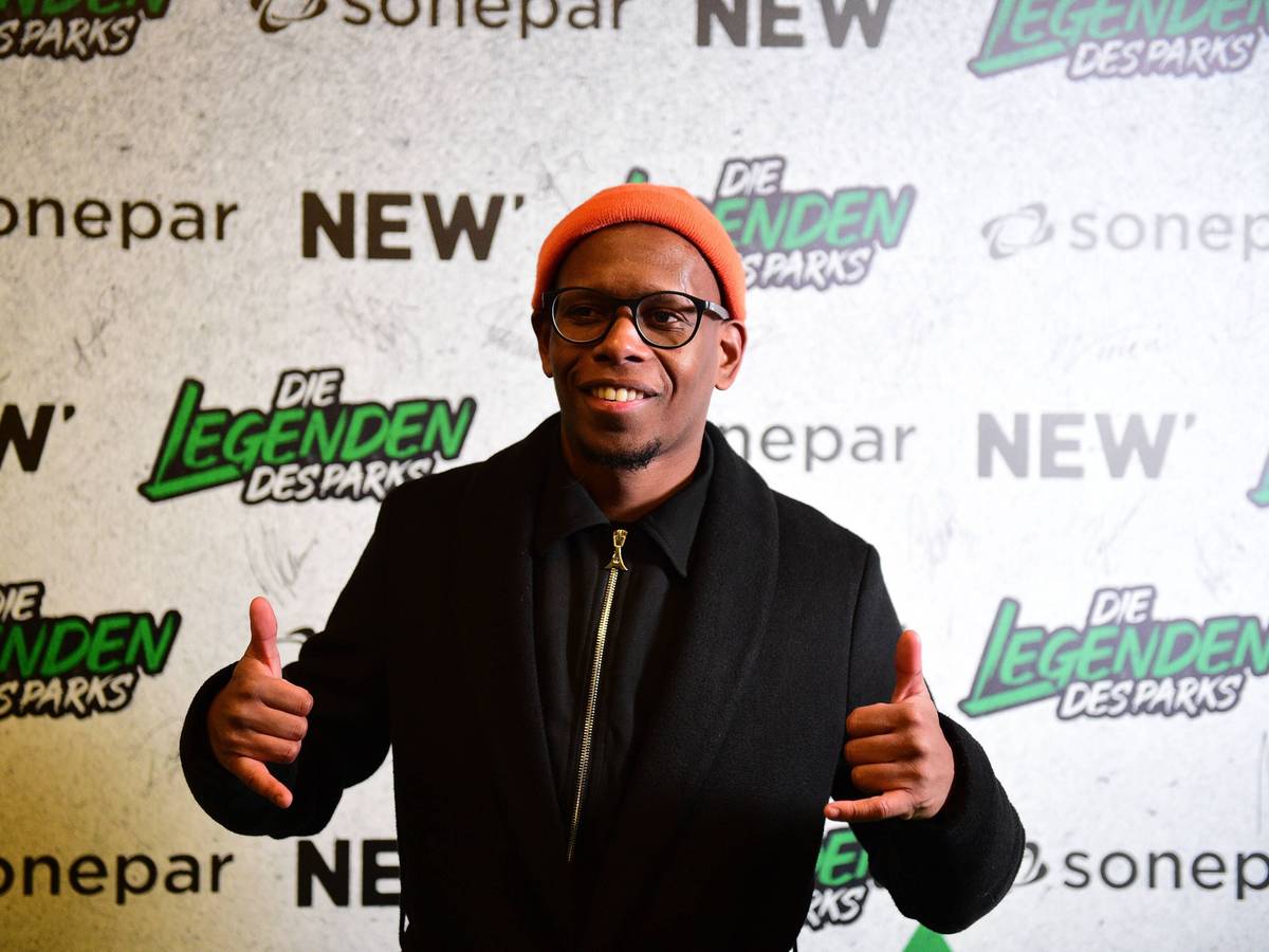 Ibrahima Traoré posiert lachend vor einer Fotowand am Nachmittag des Legendenspiels von Borussia Mönchengladbach, das am 17. Dezember 2022 im Borussia-Park stattfand.