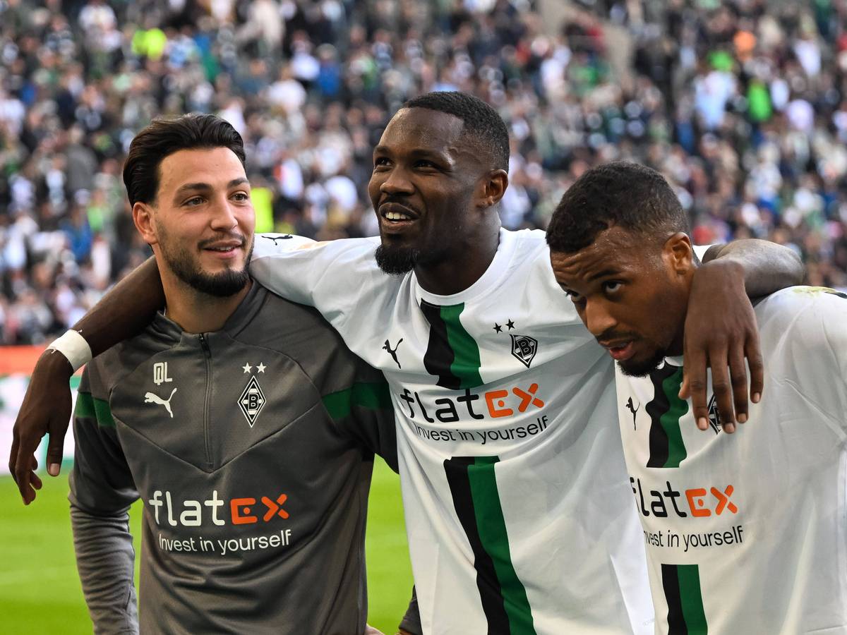 Ramy Bensebaini (l.), Marcus Thuram (Mitte) und Alassane Plea (r.) von Borussia Mönchengladbach am 9. Oktober 2022 nach dem Spiel gegen den 1. FC Köln beim Feiern mit den Fans vor der Nordkurve.