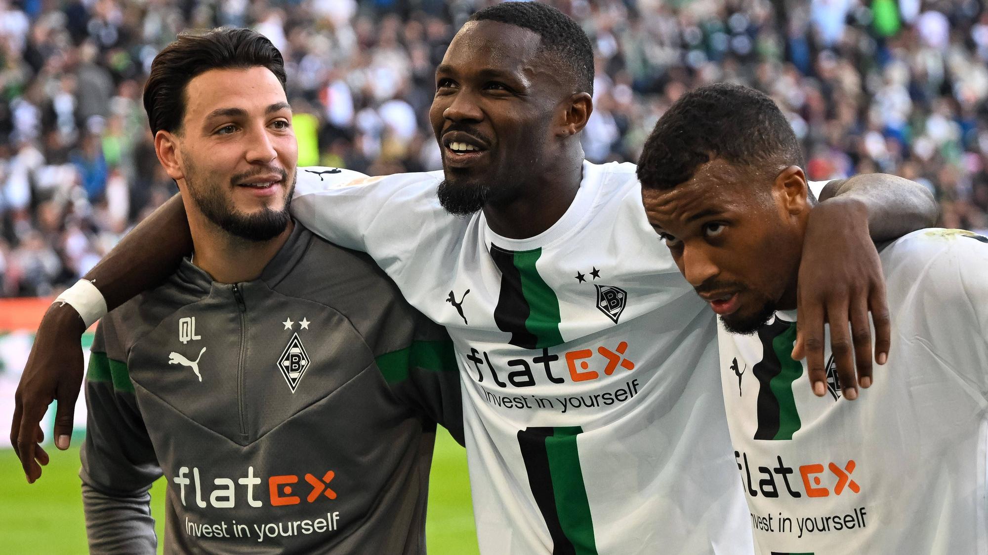 Ramy Bensebaini (l.), Marcus Thuram (Mitte) und Alassane Plea (r.) von Borussia Mönchengladbach am 9. Oktober 2022 nach dem Spiel gegen den 1. FC Köln beim Feiern mit den Fans vor der Nordkurve.