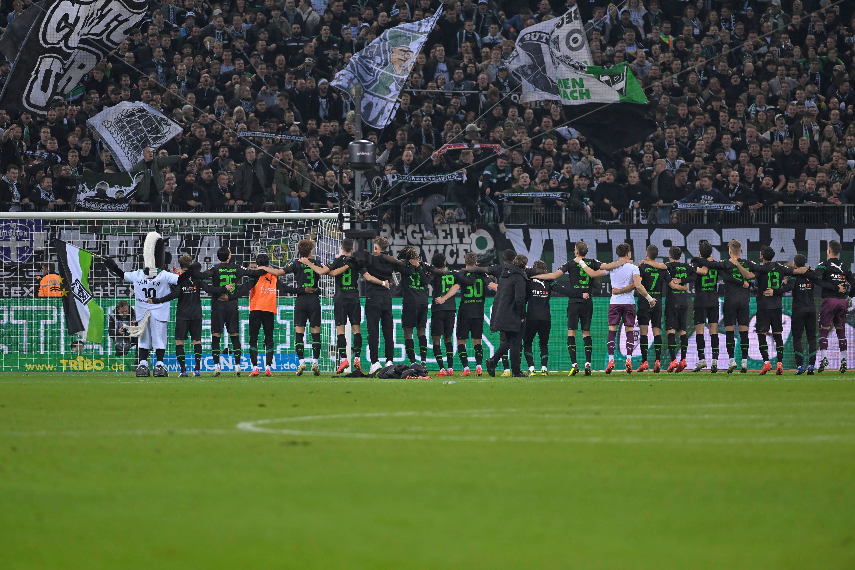Das Team von Borussia Mönchengladbach am 11. November 2022 in der Rückenansicht beim Schlussjubel vor der Nordkurve im Borussia-Park.