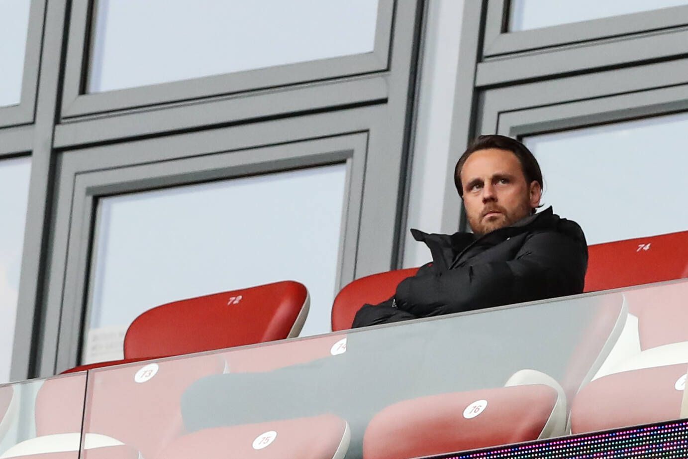 Christopher Vivell, hier am 1. Oktober 2022 bei einem Bundesliga-Spiel zwischen RB Leipzig und dem VfL Bochum, auf roten Ledersitzen im Stadion sitzend und grimmig in die Ferne schauend.