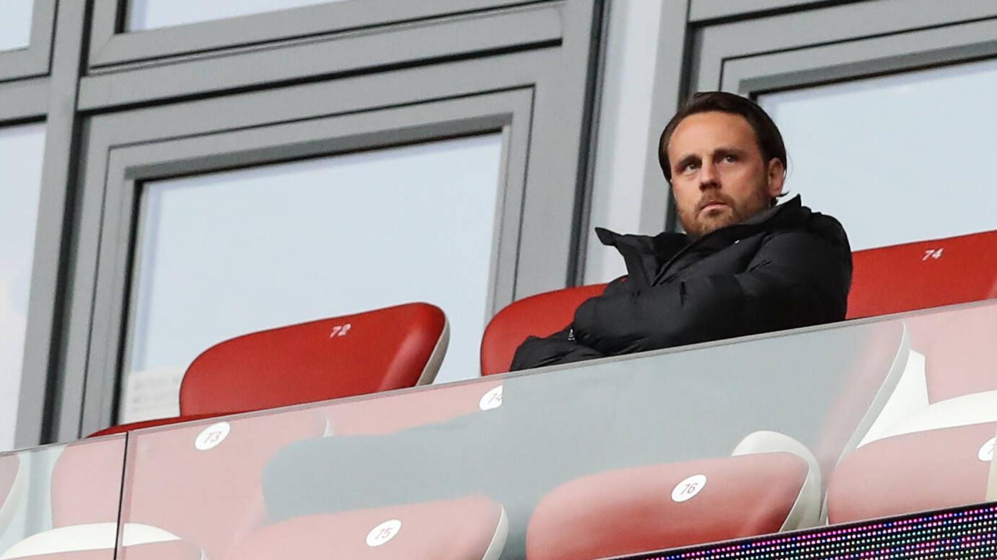 Christopher Vivell, hier am 1. Oktober 2022 bei einem Bundesliga-Spiel zwischen RB Leipzig und dem VfL Bochum, auf roten Ledersitzen im Stadion sitzend und grimmig in die Ferne schauend.