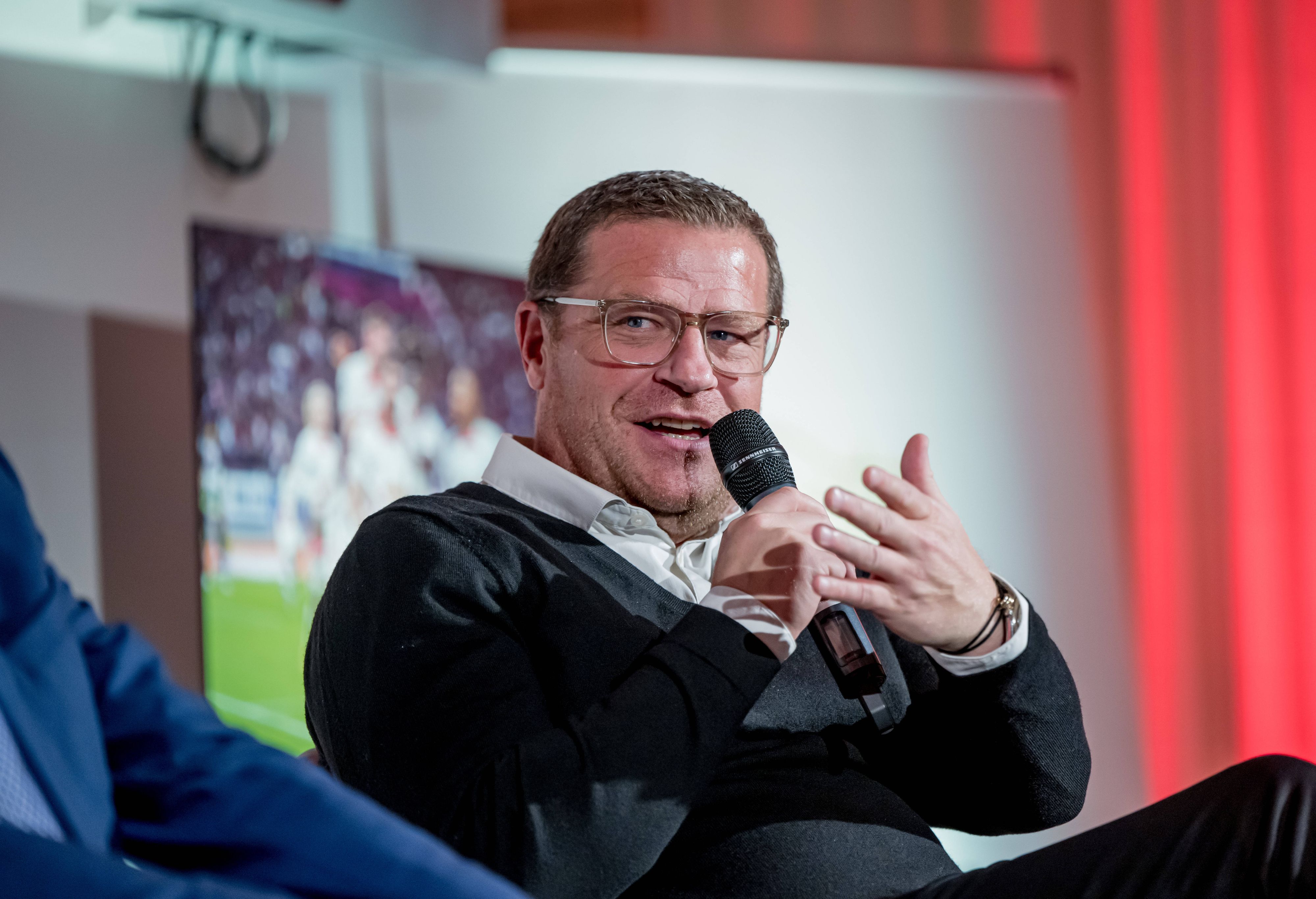 Max Eberl, Ex-Manager von Borussia Mönchengladbach und heutiger Geschäftsführer Sport bei RB Leipzig, hier am 15. Dezember 2022 bei einer Podiumsdiskussion in Berlin mit Mikrofon in der Hand sprechend und gestikulierend.