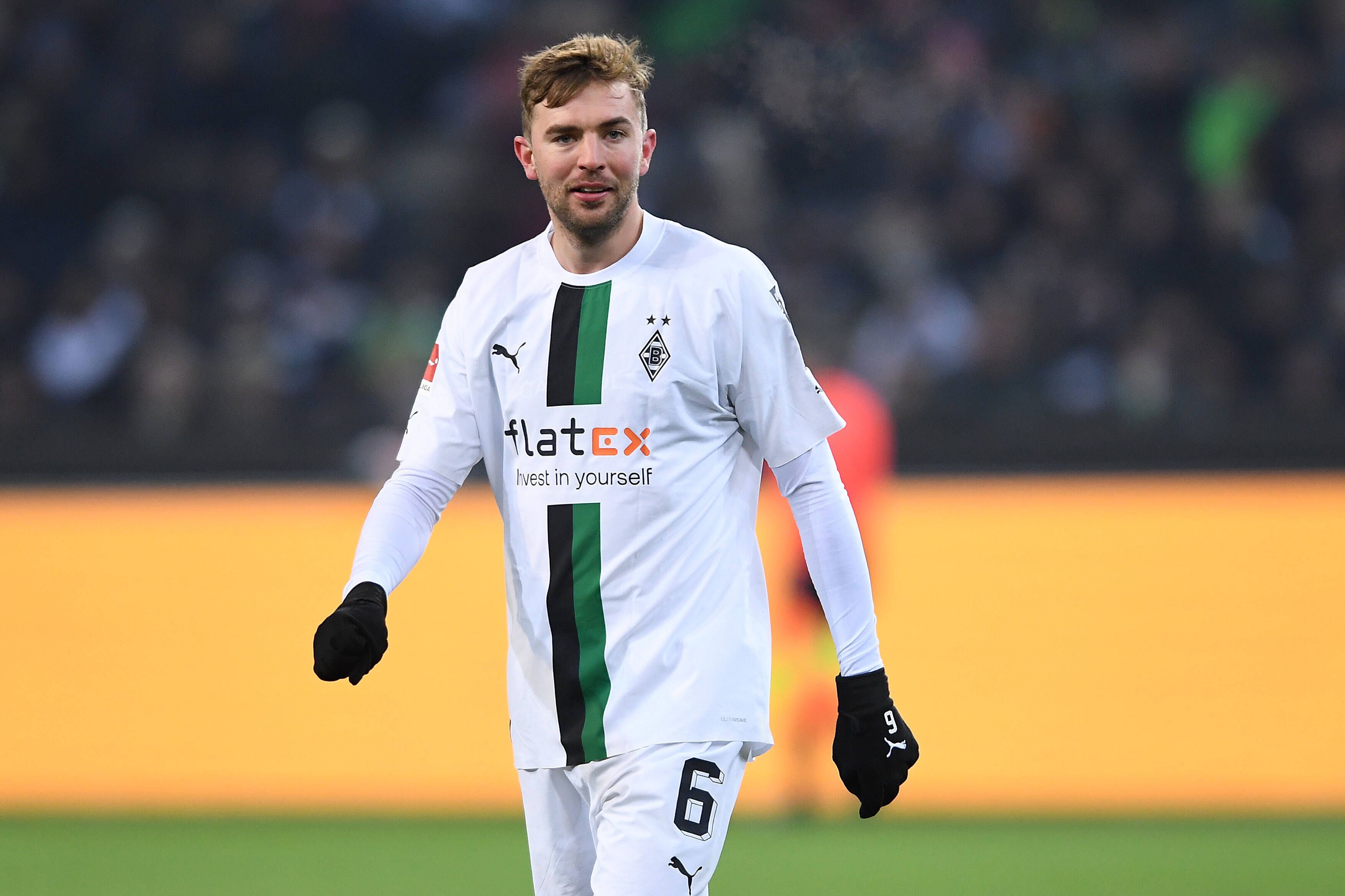 Christoph Kramer von Borussia Mönchengladbach, hier beim Spiel gegen die „Legenden des Parks“ am 17. Dezember 2022, schaut fröhlich in die Kamera. Er trägt schwarze Handschuhe.