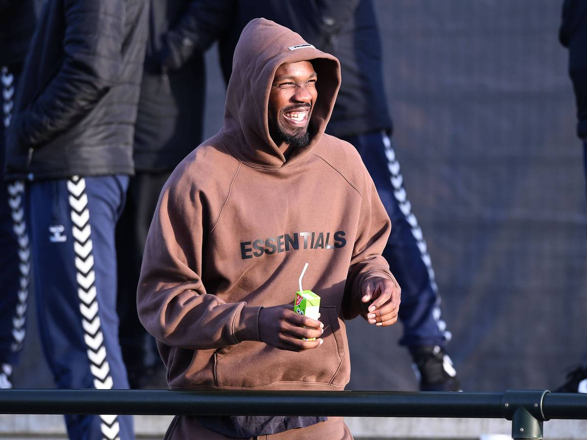 Marcus Thuram, Angreifer von Borussia Mönchengladbach, hier am 7. Januar 2023 beim Testspiel gegen den VfB Oldenburg als Zuschauer im braunen Hoodie mit Kapuze und mit Trinkpäckchen in der Hand.