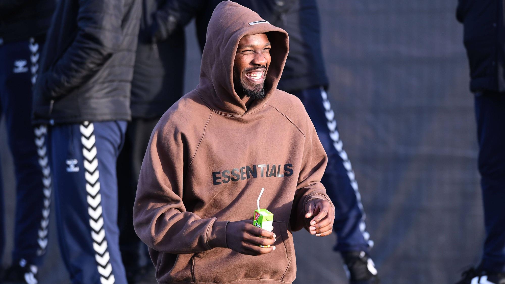 Marcus Thuram, Angreifer von Borussia Mönchengladbach, hier am 7. Januar 2023 beim Testspiel gegen den VfB Oldenburg als Zuschauer im braunen Hoodie mit Kapuze und mit Trinkpäckchen in der Hand.