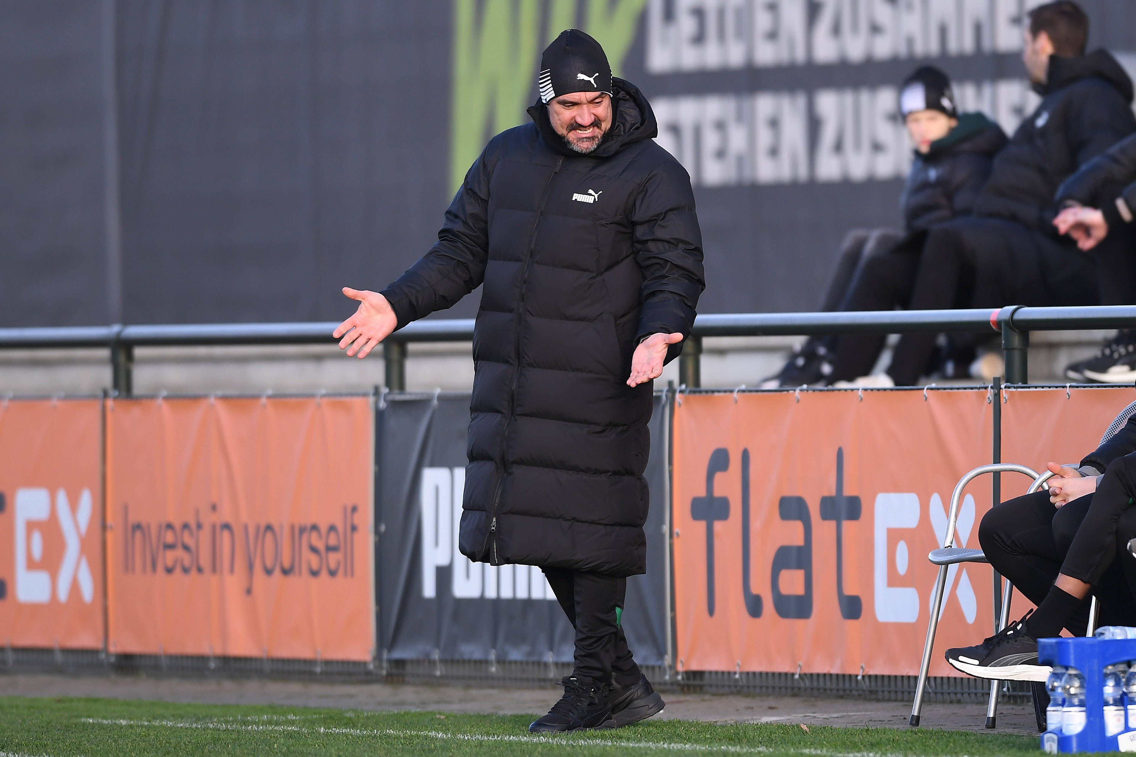 Daniel Farke steht im Testspiel von Borussia Mönchengladbach gegen den VfB Oldenburg am Spielfeldrand und gestikuliert. Der Trainer streckt seine Arme heraus und macht eine fragende Geste zu seinen Assistenten.