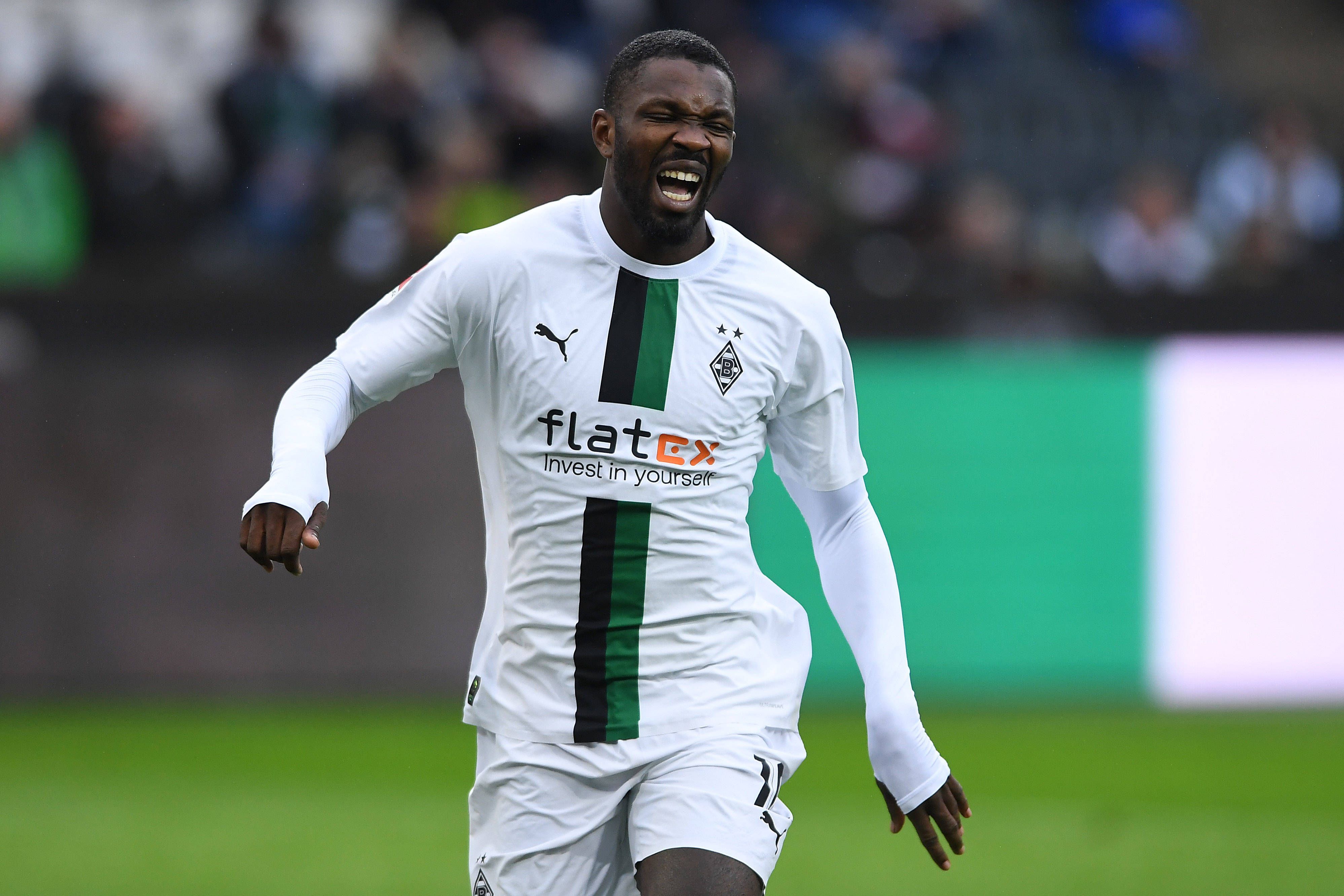 Marcus Thuram schreit vor Schmerz beim Testspiel von Borussia Mönchengladbach gegen den FC St. Pauli am 14. Januar 2023 auf. Der Gladbach-Stürmer hat den Mund weit geöffnet und kneift die Augen zu.
