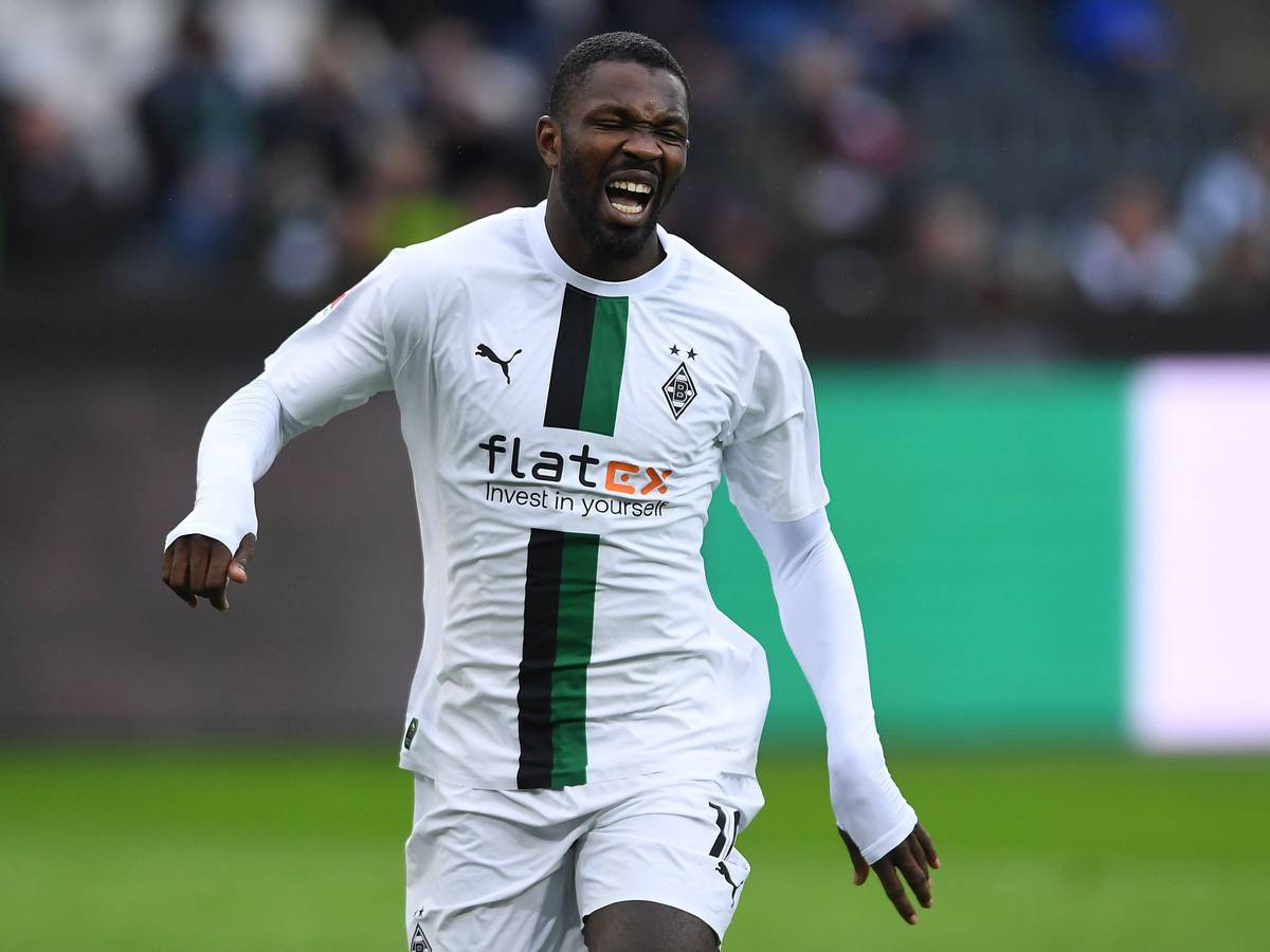 Marcus Thuram schreit vor Schmerz beim Testspiel von Borussia Mönchengladbach gegen den FC St. Pauli am 14. Januar 2023 auf. Der Gladbach-Stürmer hat den Mund weit geöffnet und kneift die Augen zu.