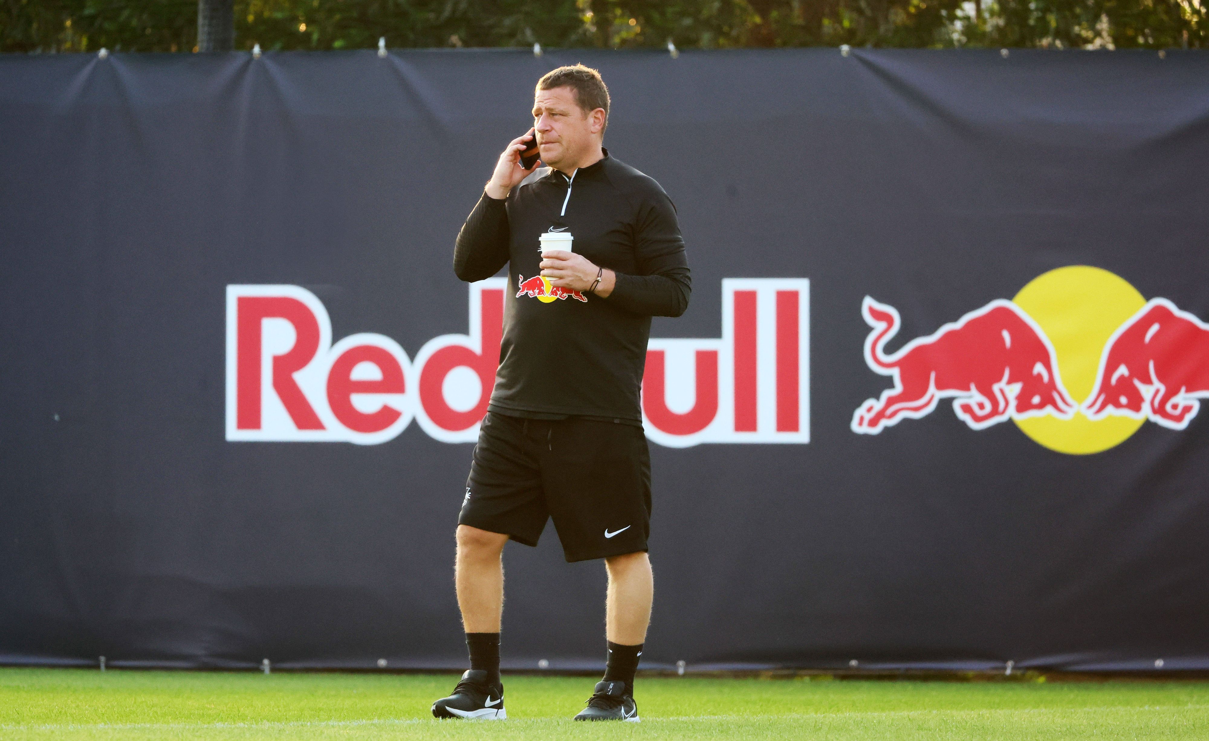 Ex-Gladbach-Manager Max Eberl, hier am 9. Januar 2023 im Trainingscamp seines neuen Klubs RB Leipzig in Abu Dhabi zu sehen. Eberl telefoniert mit seinem Smartphone, in der linken Hand hält er einen Getränkebecher.