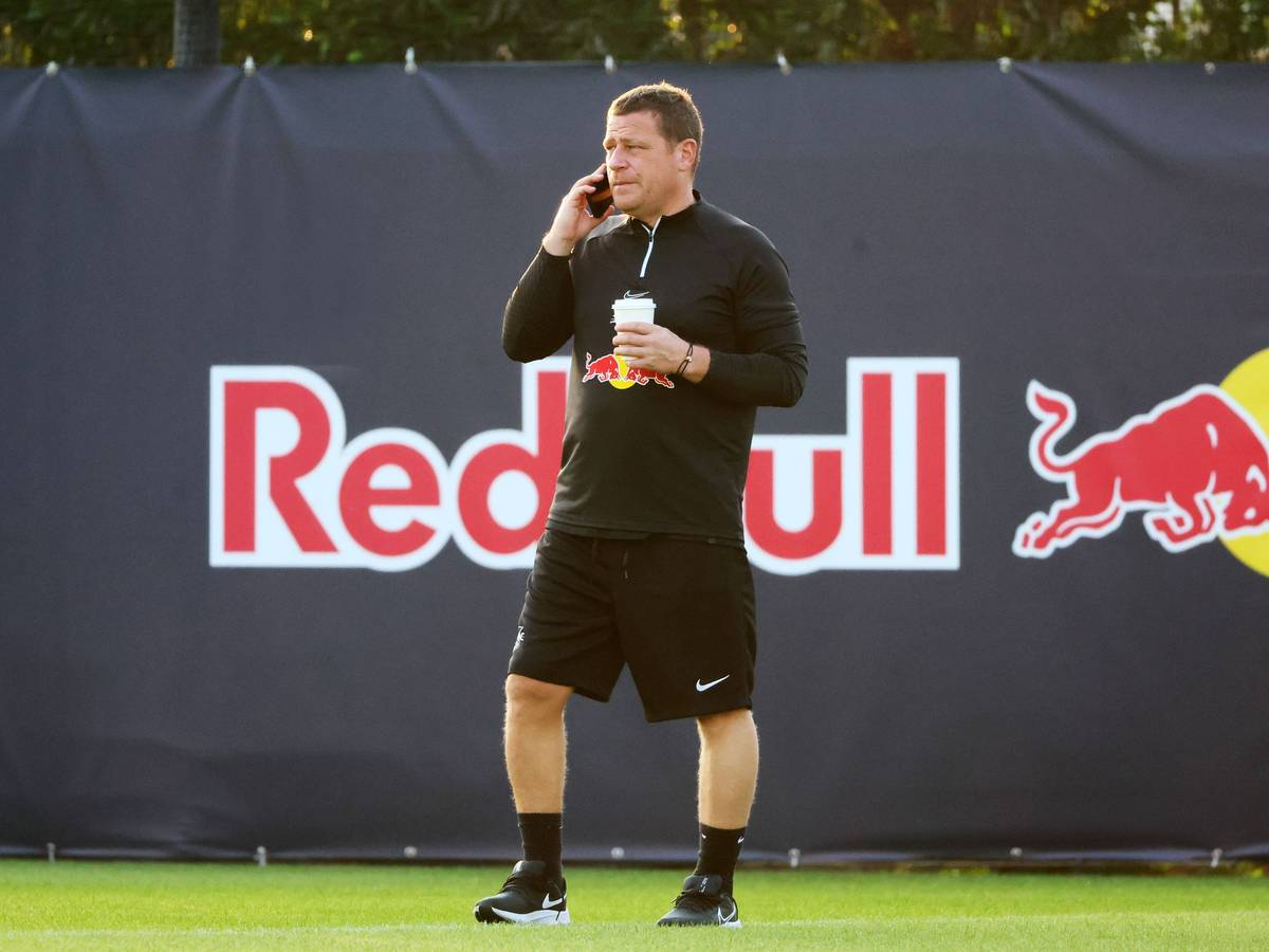 Ex-Gladbach-Manager Max Eberl, hier am 9. Januar 2023 im Trainingscamp seines neuen Klubs RB Leipzig in Abu Dhabi zu sehen. Eberl telefoniert mit seinem Smartphone, in der linken Hand hält er einen Getränkebecher.