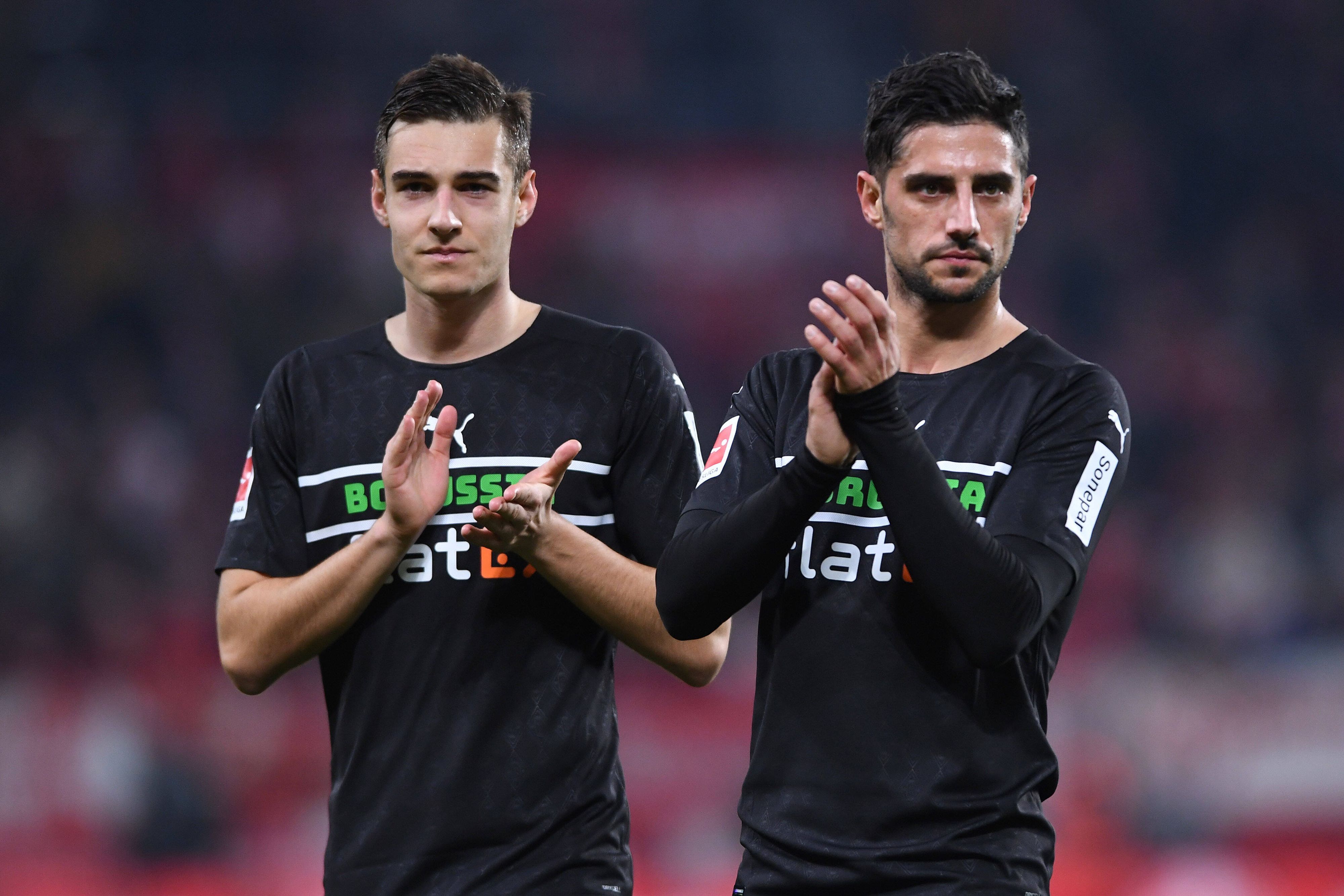 Florian Neuhaus (l.) und Lars Stindl (r.) von Borussia Mönchengladbach, hier am 5. November 2021 beim Auswärtsspiel in Mainz, klatschen nach der Partie den mitgereisten Fans zu. Beuide schauen missmutig und haben ein schwarzes Gladbach-Trikot an.