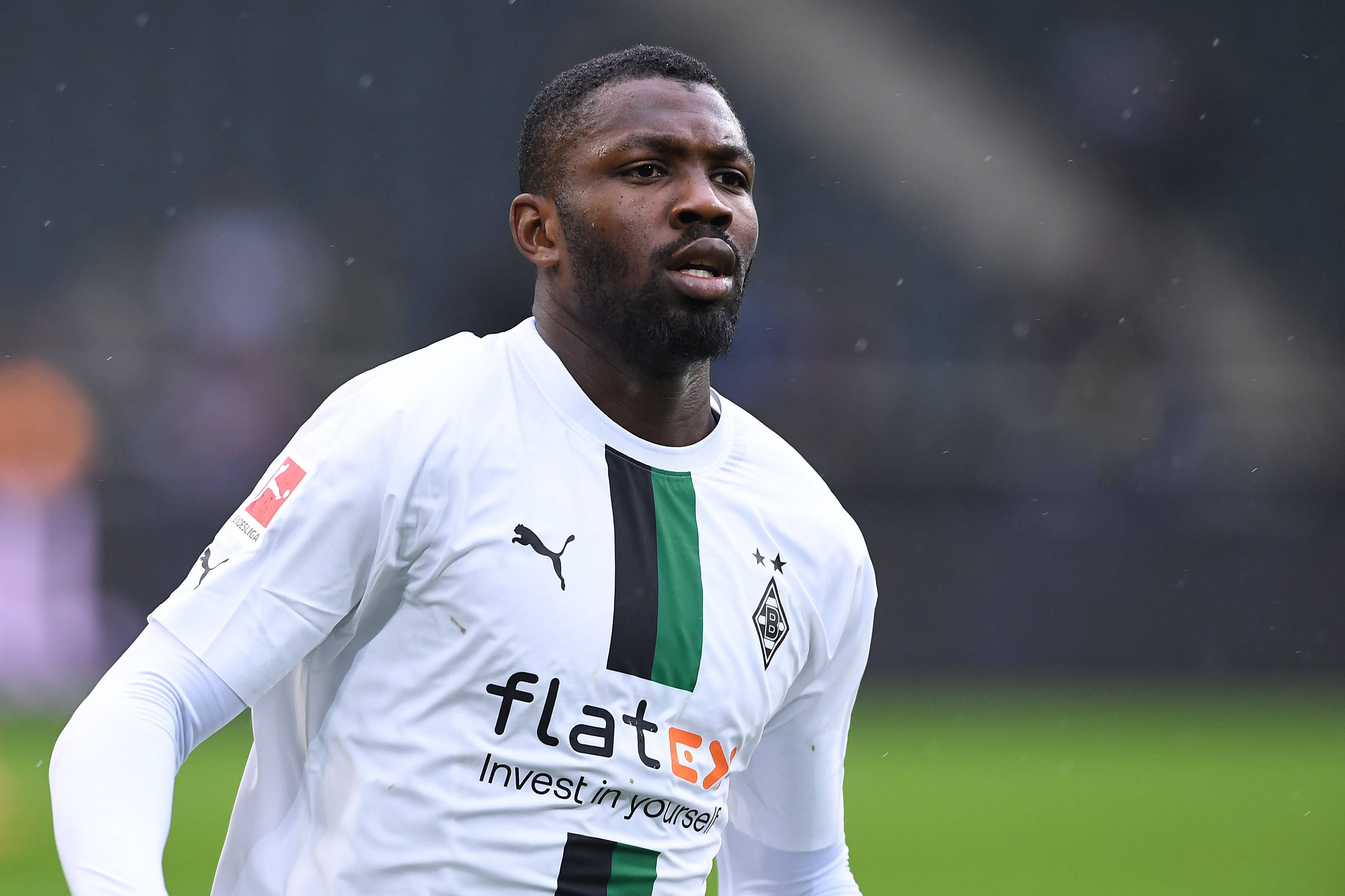 Marcus Thuram von Borussia Mönchengladbach, hier am 14. Januar 2023 beim Testspiel gegen den FC St. Pauli mit konzentriertem Blick in Nahaufnahme. Er trägt ein weißes Borussia-Trikot mit schwarz-grünem Streifen.