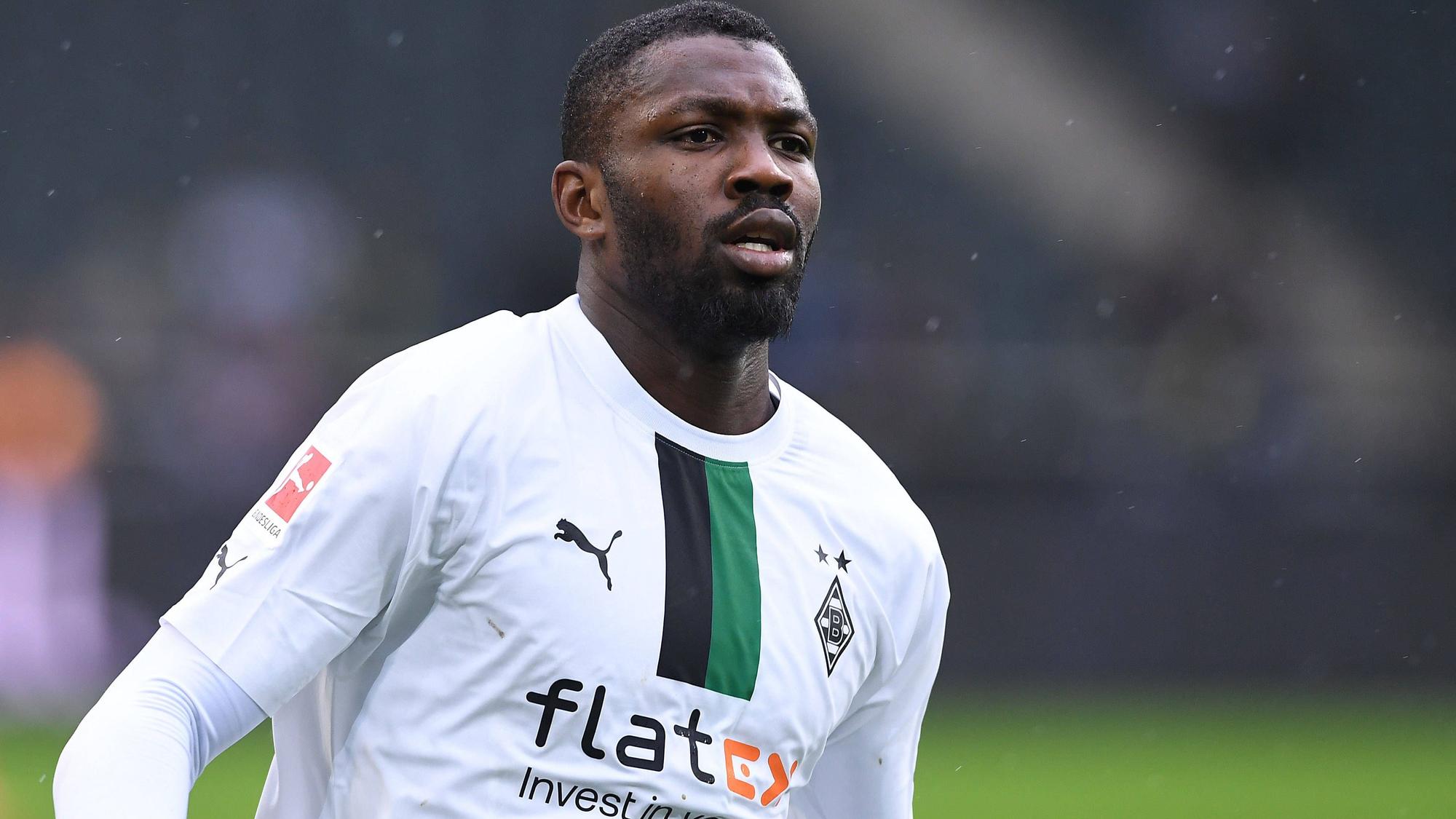 Marcus Thuram von Borussia Mönchengladbach, hier am 14. Januar 2023 beim Testspiel gegen den FC St. Pauli mit konzentriertem Blick in Nahaufnahme. Er trägt ein weißes Borussia-Trikot mit schwarz-grünem Streifen.