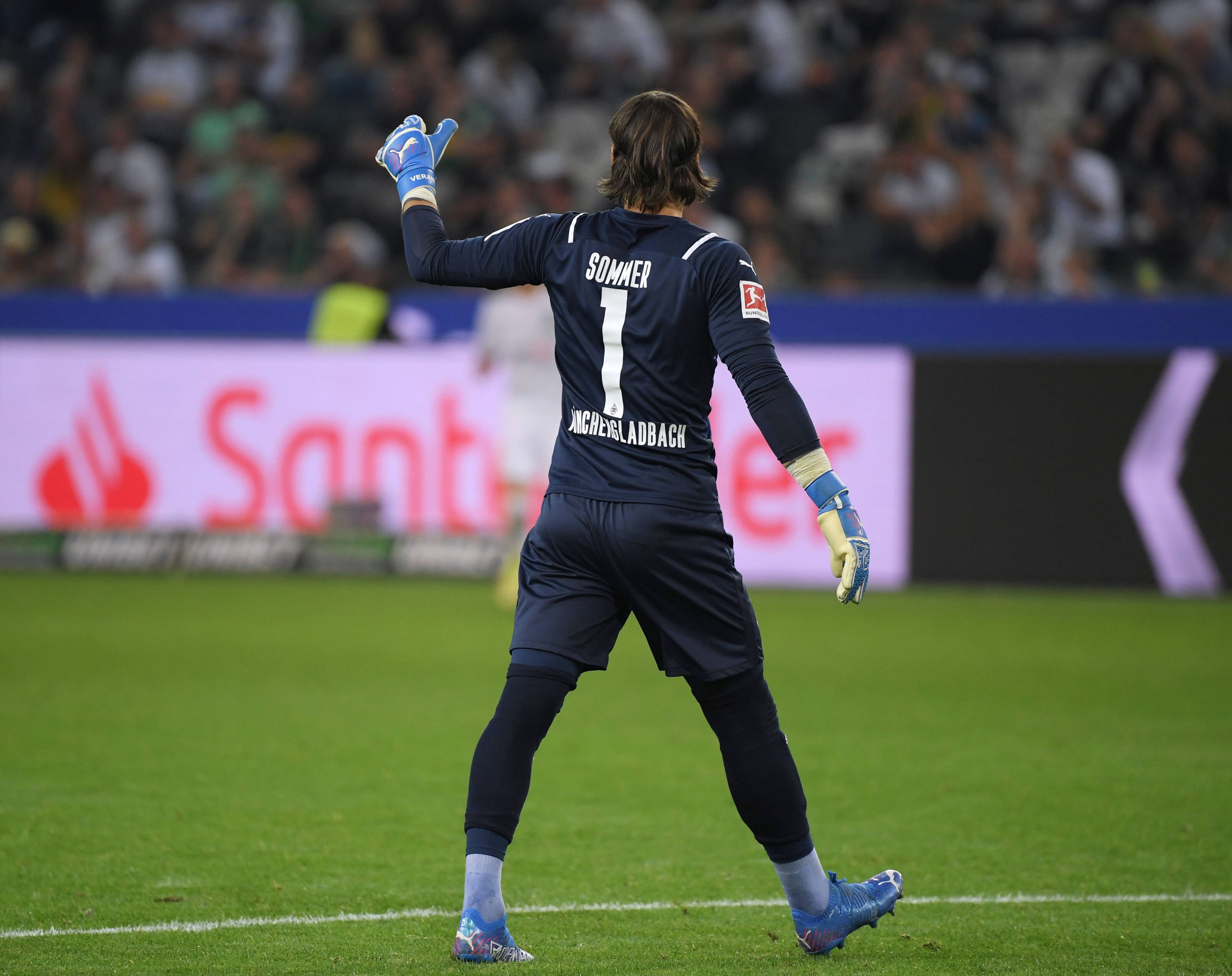 Blick auf Yann Sommer im Trikot von Borussia Mönchengladbach von hinten, der Torhüter trägt ein dunkelblaues Trikot und die Rückennummer 1.