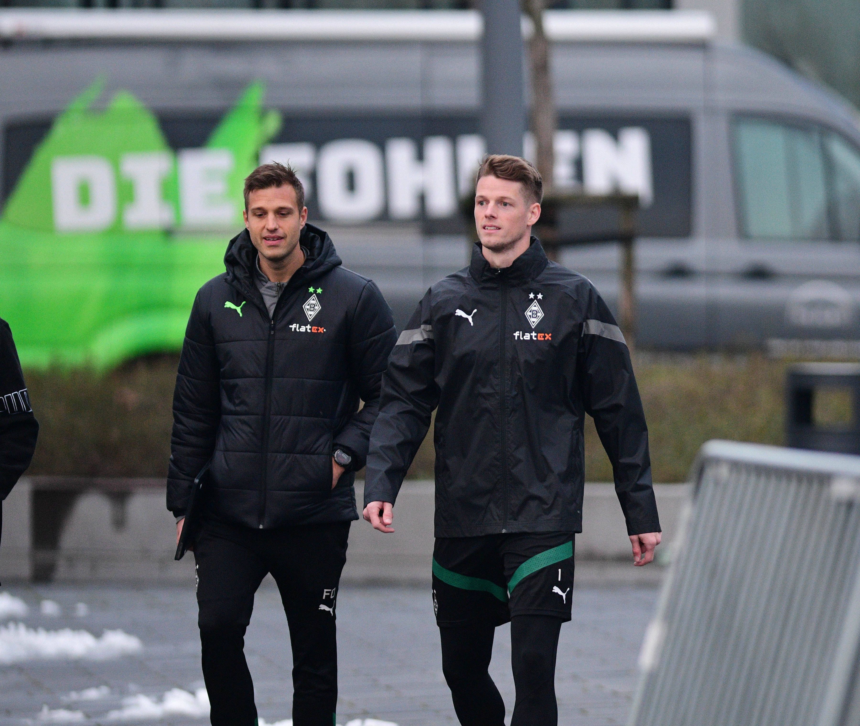 Jonas Omlin (r.) ist neuer Torwart von Fußball-Bundesligist Borussia Mönchengladbach. Der Schweizer Nationalspieler ist hier gemeinsam mit Torwarttrainer Fabian Otte (l.) bei seiner Premiere (19. Januar 2023) im Borussia-Park zu sehen. Otte und Omlin gehen gemeinsam zum Trainingsgelände.