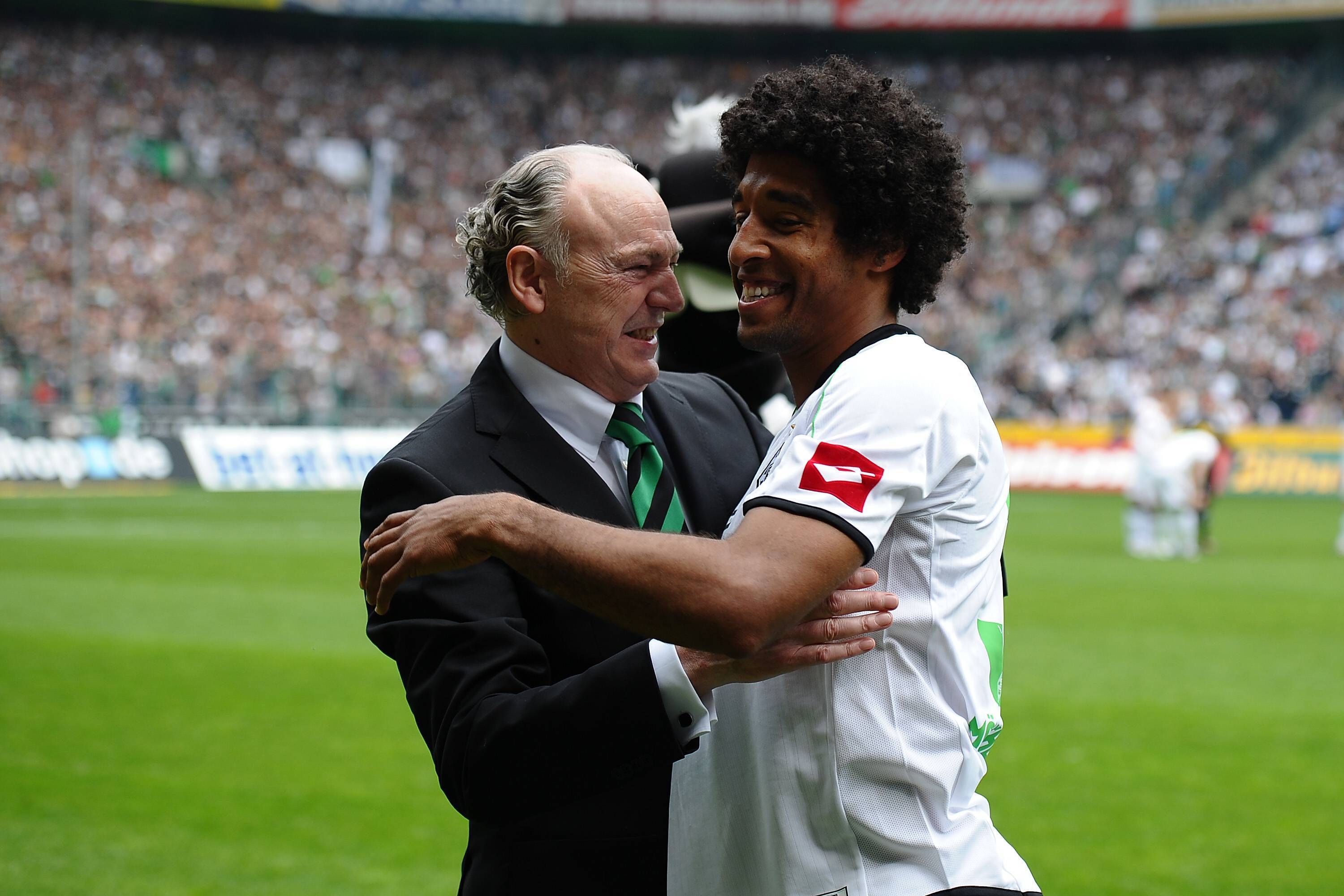 Dante (r.) umarmt Rolf Königs, Präsident von Borussia Mönchengladbach, bei seiner Verabschiedung am 28. April 2012. Dante trägt das weiße Heimtrikot von Gladbach, Königs einen Anzug.