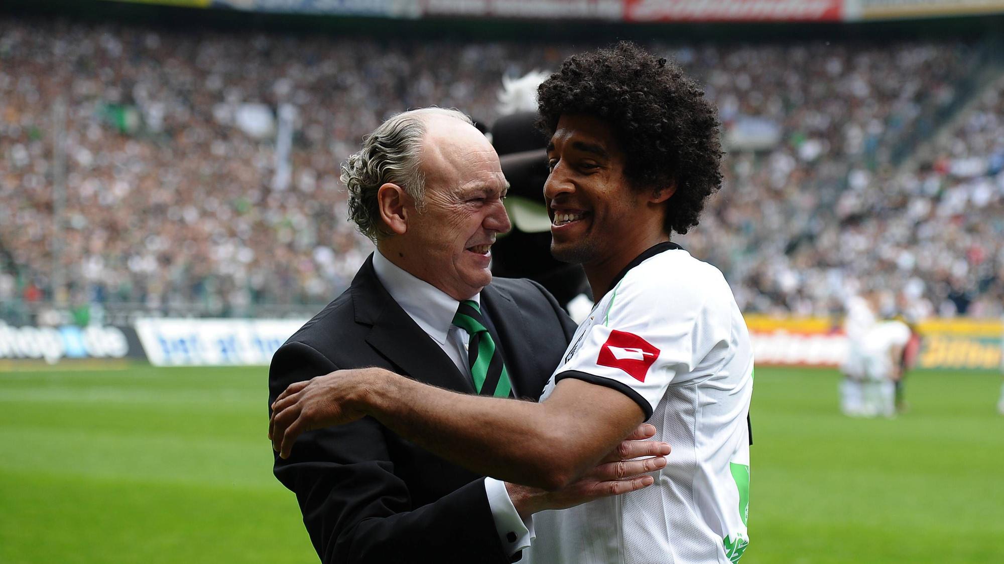 Dante (r.) umarmt Rolf Königs, Präsident von Borussia Mönchengladbach, bei seiner Verabschiedung am 28. April 2012. Dante trägt das weiße Heimtrikot von Gladbach, Königs einen Anzug.