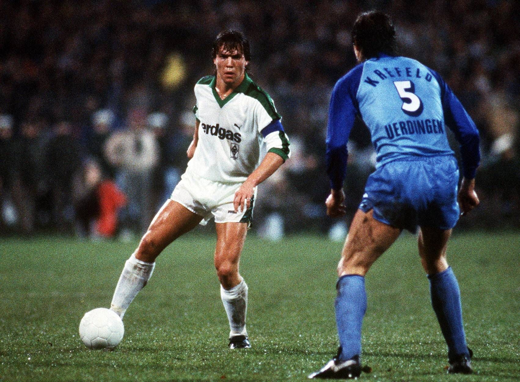 Lothar Matthäus spielt den Ball in der Bundesliga-Partie gegen Bayer Uerdingen am 25. November 1983 und trägt ein weißes Trikot von Borussia Mönchengladbach.